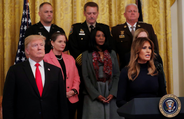 President Trump listens as first lady Melania Trump speaks about the apparent pipe bombs sent in packages addressed to Democratic political figures in New York, Washington and Florida during an event in the East Room of the White House on administration efforts to "combat the opioid crisis" in Washington, U.S., October 24, 2018. REUTERS/Leah Millis