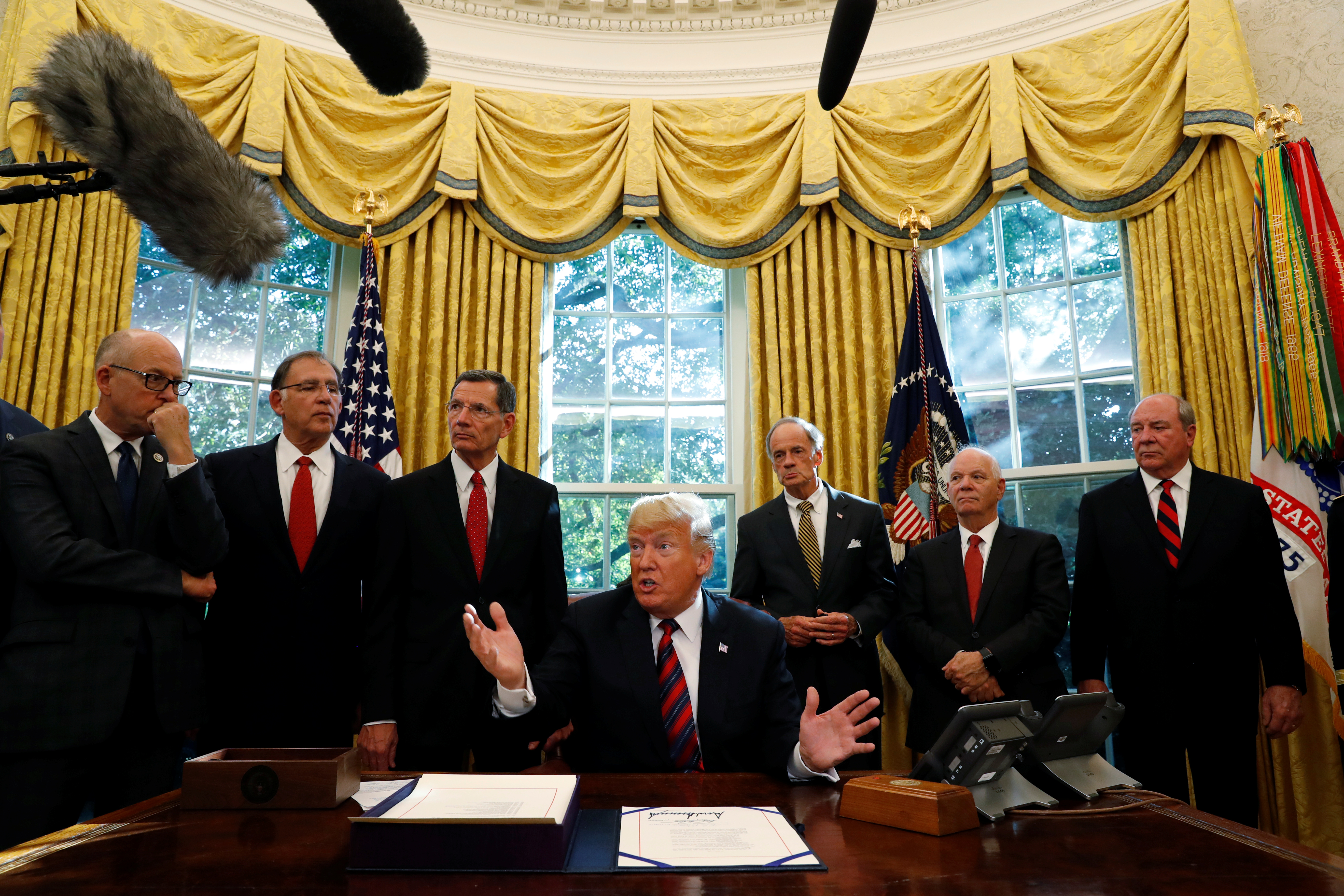 U.S. President Trump talks to reporters during bill signing ceremony at the White House in Washington