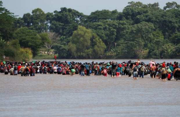 Central American migrants walk through the Suchiate river, the natural border between Guatemala and Mexico, in their bid to reach the U.S., as seen from Tecun Uman