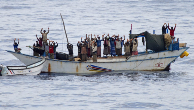 Hostages and pirates stand with their hands up before the intervention of Dutch NATO soldiers off Somalia's coast in this NATO handout photo made available April 18, 2009. Dutch commandos freed 20 Yemeni hostages on Saturday and briefly detained seven pirates who had forced the Yemenis to sail a "mother ship" attacking vessels in the Gulf of Aden, NATO officials said. REUTERS/NATO/Handout (SOMALIA CONFLICT SOCIETY POLITICS MILITARY IMAGE OF THE DAY TOP PICTURE) FOR EDITORIAL USE ONLY. NOT FOR SALE FOR MARKETING OR ADVERTISING CAMPAIGNS - GM1E54J03X601