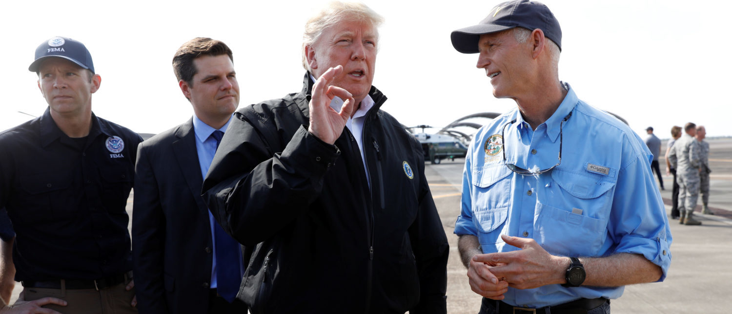 U.S. President Donald Trump stands with FEMA Administrator Brock Long (L) and U.S. Rep Ron DeSantis (R-FL) as he talks to Florida Governor Rick Scott (R) after the president arrived to tour storm damage from Hurricane Michael at Eglin Air Force Base, Florida, U.S., October 15, 2018. REUTERS/Kevin Lamarque