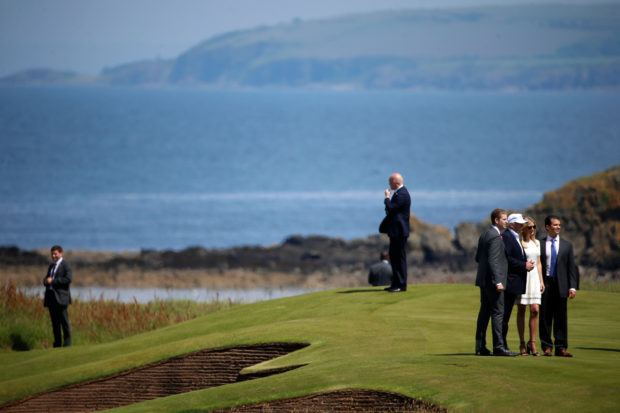 Secret Service agents keep watch as Eric Trump (L), Republican presidential candidate Donald Trump (2nd L), Ivanka Trump and Donald Trump Jr. (R) pose for a photo following a news conference at Turnberry Golf course in Turnberry, Scotland, June 24, 2016. REUTERS/Carlo Allegri