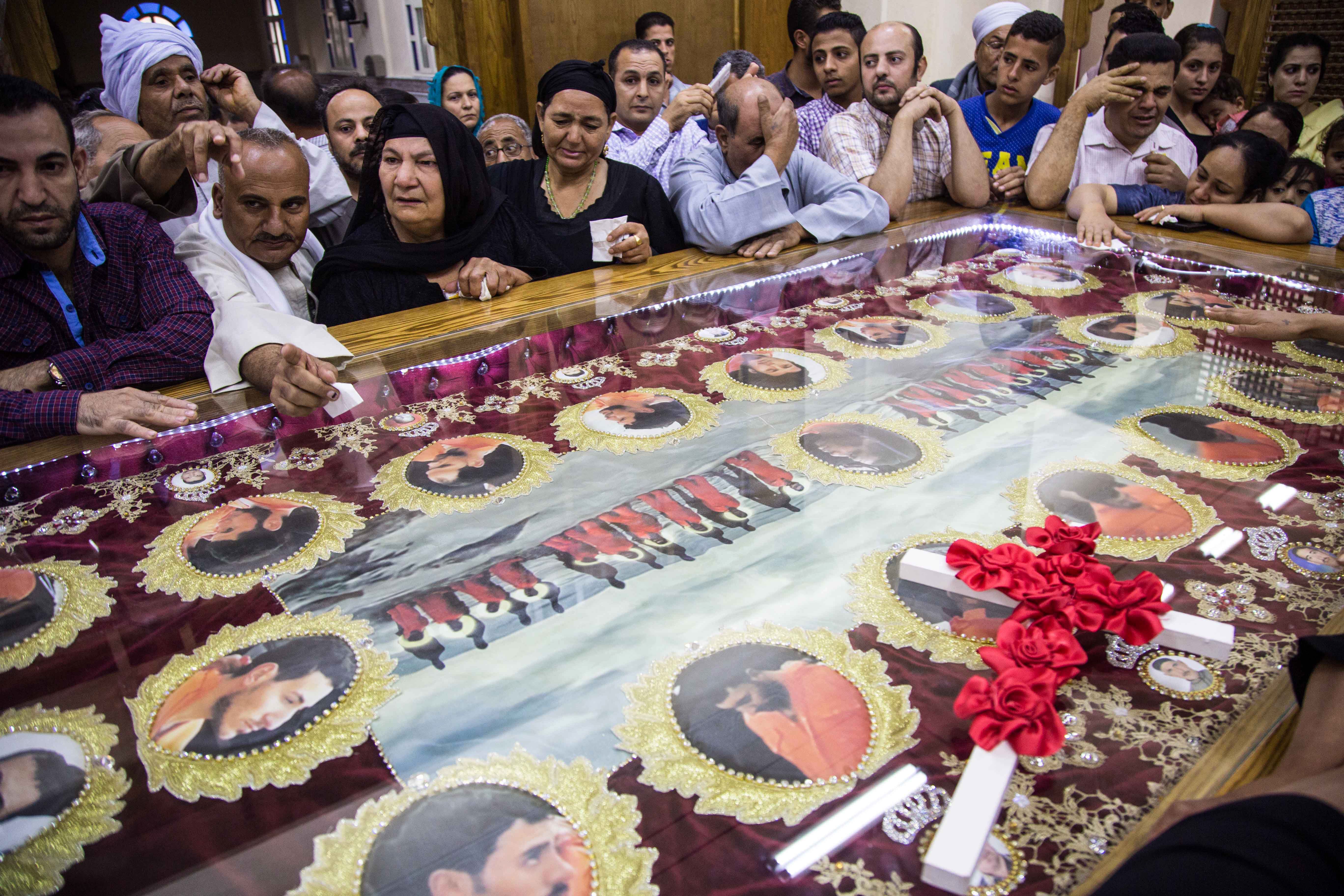 Relatives pray and mourn over the repatriated remains of 20 Egyptian Coptic Orthodox Christian men who were beheaded by jihadists on the beach of the Libyan city of Sirte in Libya in 2015, during their funeral ceremony at the Church of the Martyrs in the village of Al-Our in Egypt's southern Minya province on May 15, 2018. - The remains arrived home on May 15, 2018, an official at Cairo airport said, after being flown in from Misrata on a Libyan Afriqiyah Airways cargo plane. The doctor supervising the task of identifying the bodies said it was "not an easy task", as they had decomposed and the heads had been separated from the torsos, having to rely on DNA samples sent by the victims' families. (IBRAHIM EZZAT/AFP/Getty Images)