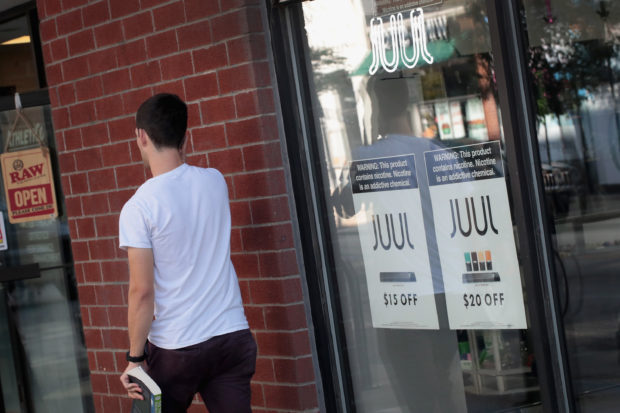 Signs in the window of the Smoke Depot advertise electronic cigarettes and pods by Juul, the nation's largest maker of e-cigarette products, on September 13, 2018 in Chicago, Illinois. Scott Olson/Getty Images