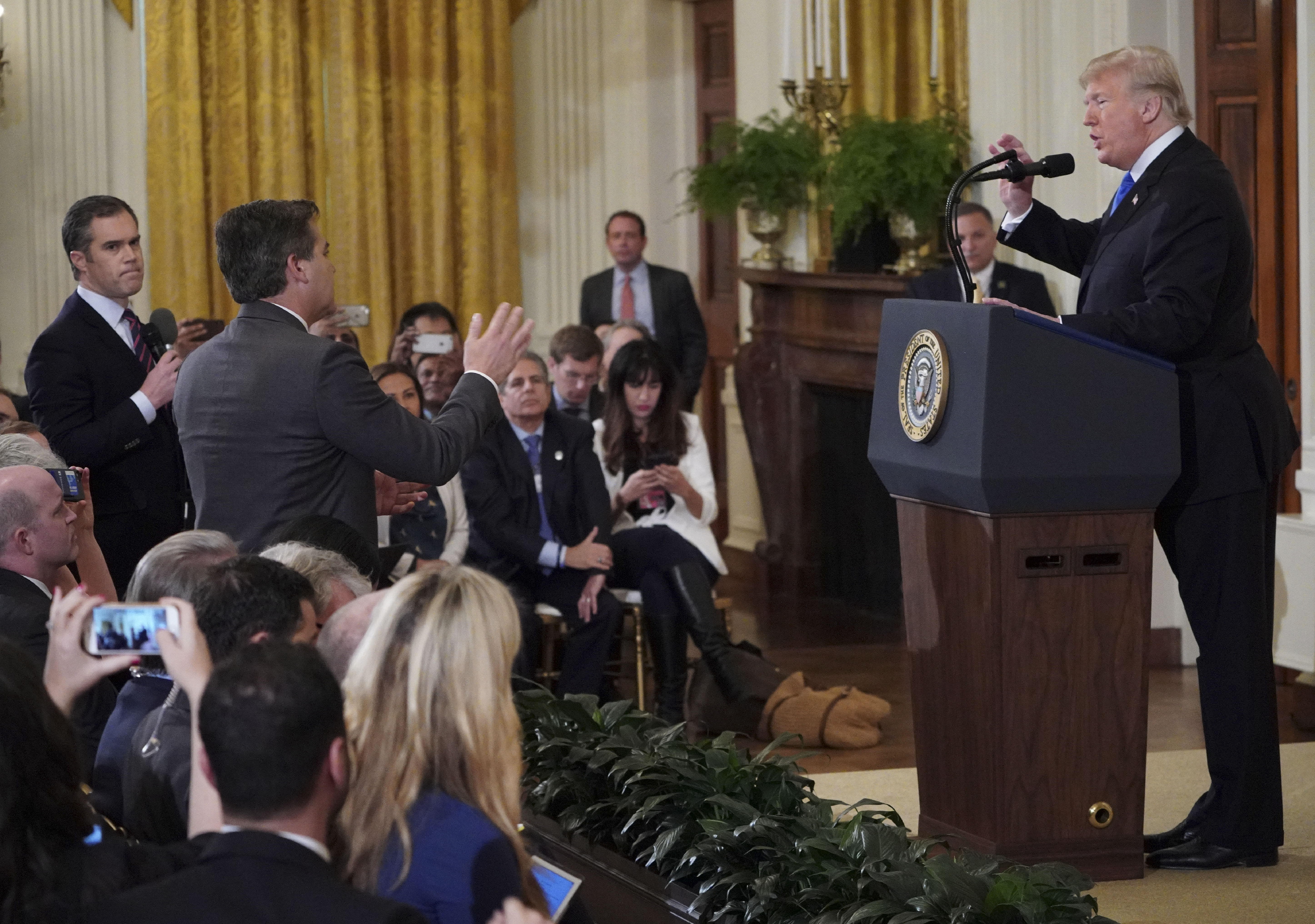 US President Donald Trump (R) gets into a heated exchange with CNN chief White House correspondent Jim Acosta (C) as NBC correspondent Peter Alexander (L) looks on during a post-election press conference in the East Room of the White House in Washington, DC on November 7, 2018. (Photo by Mandel NGAN / AFP)