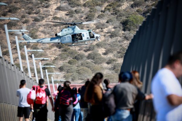 A United States Military helicopter flies past a pedestrian bridge after the closing of the United States-Mexico border was ordered on November 25, 2018 at the San Ysidro border crossing point south of San Diego, California. - US officials closed a border crossing in southern California on Sunday after hundreds of migrants tried to breach a border fence from the Mexican city of Tijuana, US authorities announced. The US Customs and Border Protection office in San Diego, California, said on Twitter that it had closed both north and south access to vehicle traffic at the San Ysidro border post, before also suspending pedestrian crossings. (Photo by Sandy Huffaker / AFP) (Photo credit should read SANDY HUFFAKER/AFP/Getty Images)