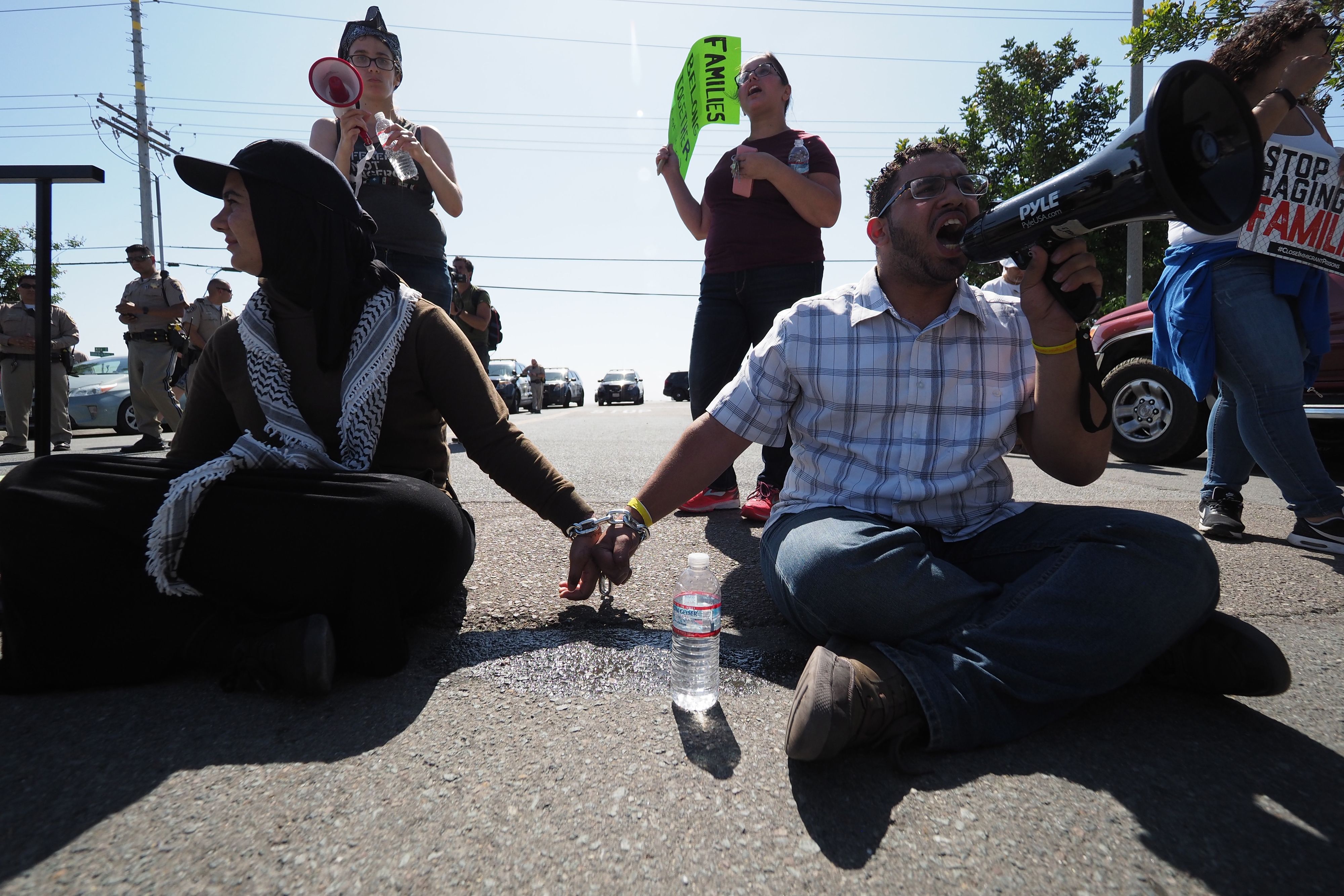 Protestors chained together at the wrist block traffic from passing on the road to the Otay Mesa Detention Center during a demonstration against US immigration policy that separates children from parents, in San Diego, California June 23, 2018. ROBYN BECK/AFP/Getty Images