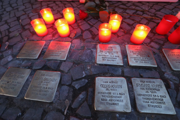 BERLIN, GERMANY - NOVEMBER 09: Candles placed at Stolpersteine by local people commemorating the 75th anniversary of the Kristallnacht pogroms cast light on the names of Jewish residents murdered in the Holocaust on November 9, 2013 in Berlin, Germany. Stolpersteine are concrete cobblestones afixed with brass plaques that memorialize local Jewish residents who were murdered or expelled by the Nazis. Events are taking place across Germany today and tomorrow to commemorate the day in 1938 when Nazi gangs across Germany and Austria burned down over 1,000 synagogues, smashed Jewish-owned businesses, looted Jewish residences and killed several hundred Jews. Anti-Semitism was a central component of Adolf Hitler's rise to power and won him wide-spread sympathy among ordinary Germans and Austrians. (Photo by Sean Gallup/Getty Images)