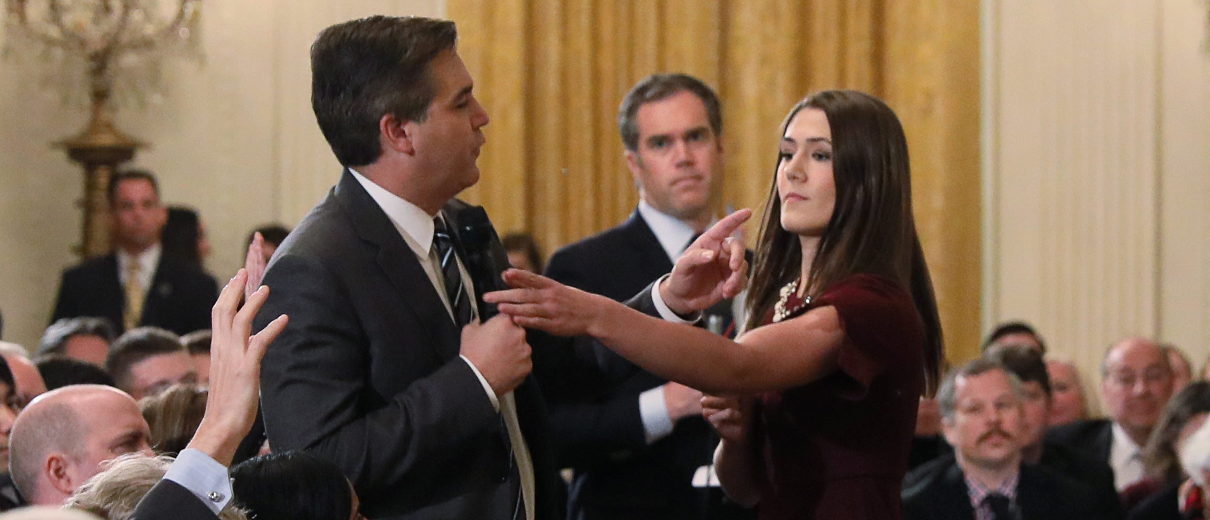 A White House intern reaches for and tries to take away the microphone held by CNN correspondent Jim Acosta as he questions President Donald Trump during a news conference at the White House in Washington, November 7, 2018. REUTERS/Jonathan Ernst