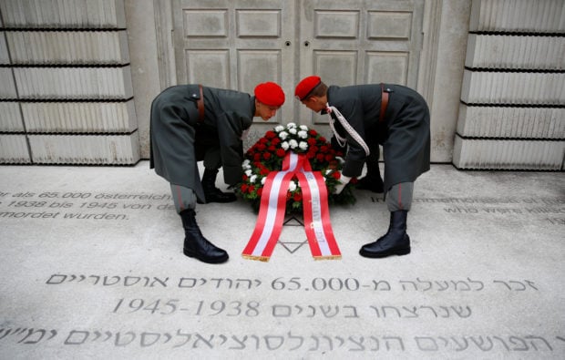 Members of the Austrian armed forces adjust a wreath during a ceremony to mark the 80th anniversary of Kristallnacht, also known as Night of Broken Glass, in front of the Holocaust Memorial in Vienna, Austria November 9, 2018. REUTERS/Leonhard Foeger
