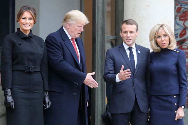 US President Donald Trump (2L) stretches his hand out to shake hands with French President Emmanuel Macron (2R) next to US First Lady Melania Trump (L) and French President's wife Brigitte Macron at the Elysee Palace in Paris on November 10, 2018 following bilateral talks on the sidelines of commemorations marking the 100th anniversary of the 11 November 1918 armistice, ending World War I. (Photo credit: LUDOVIC MARIN/AFP/Getty Images)