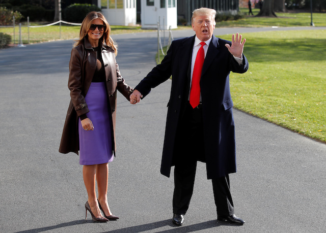 U.S. President Donald Trump talks to reporters with first lady Melania Trump by his side as they depart for travel to the G-20 summit in Argentina from the White House in Washington, U.S., November 29, 2018. REUTERS/Jim Young 