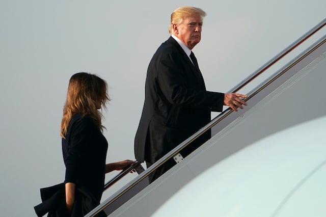 US President Donald Trump (R) and First Lady Melania Trump make their way to board Air Force One before departing from Palm Beach International Airport in West Palm Beach, Florida on November 25, 2018. - Trump is returning to Washington after spending the Thanksgiving holiday at his Mar-a-Lago resort. (Photo credit: MANDEL NGAN/AFP/Getty Images)