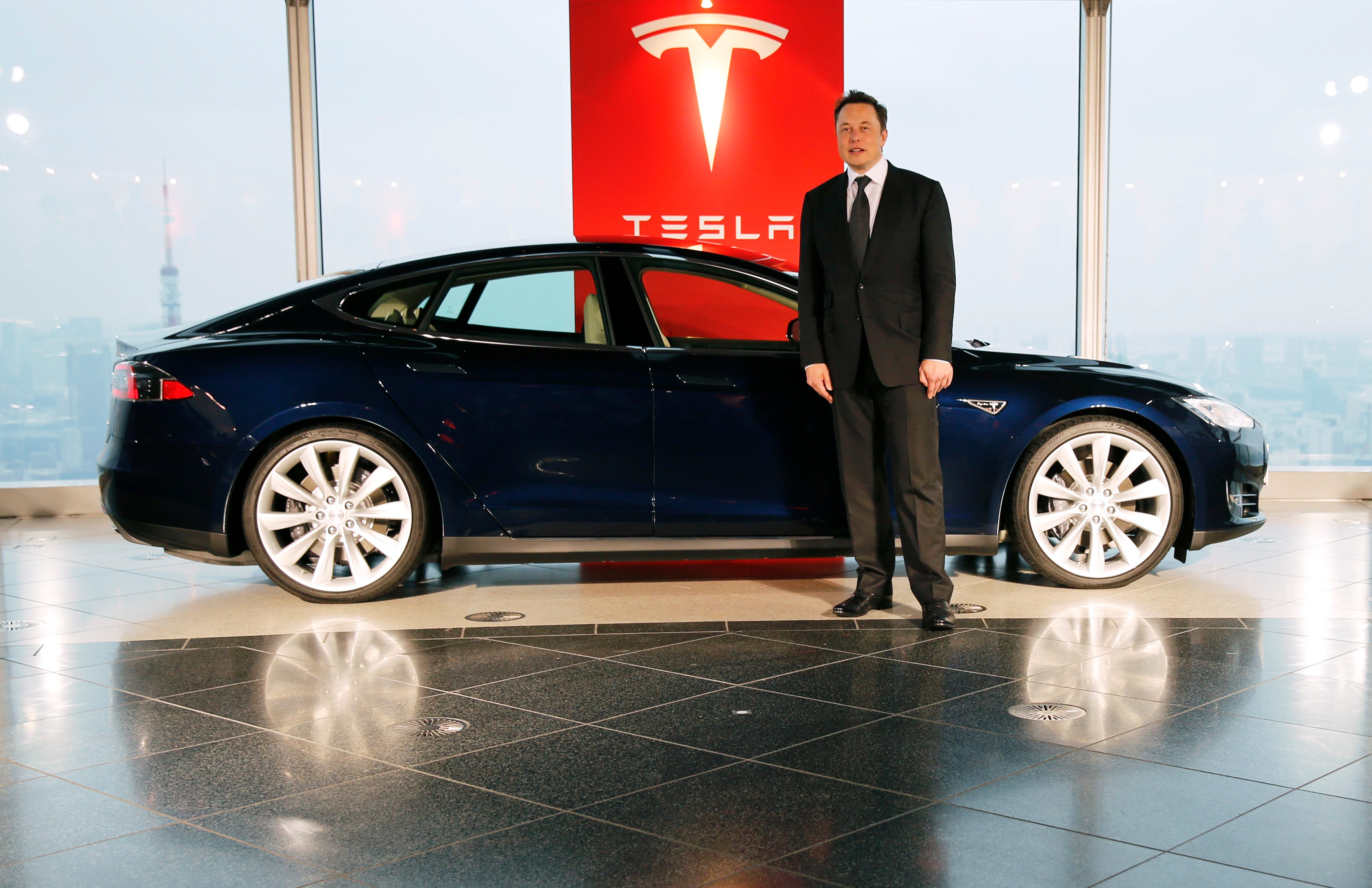 Tesla Motors Inc Chief Executive Musk poses with a Tesla Model S electric car in Tokyo