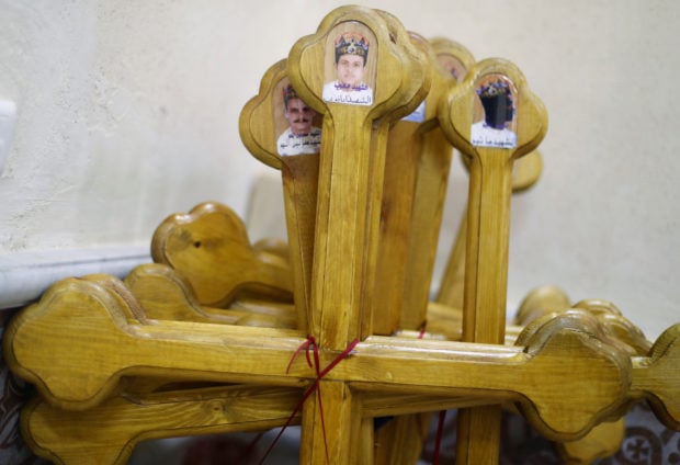 Pictures depicting Egyptian Christians who were beheaded in Libya by Islamic State in 2015, are seen on crosses during their funeral ceremony at a church in al-Our village south of Cairo
