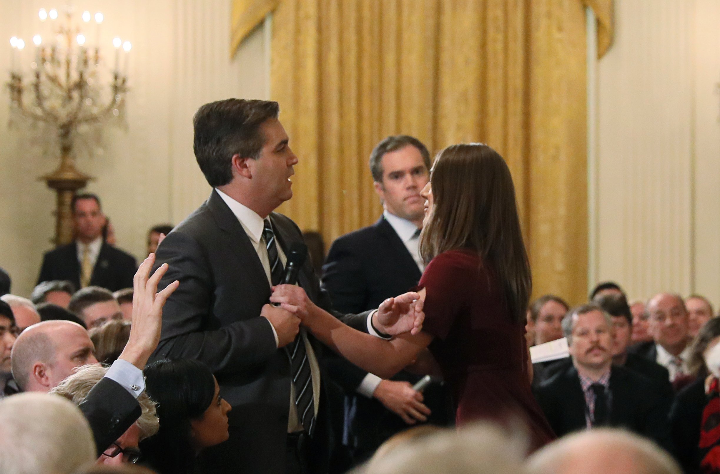 A White House intern reaches for and tries to take away the microphone held by CNN correspondent Jim Acosta as he questions U.S. President Donald Trump during a news conference at the White House in Washington, U.S., November 7, 2018. Picture taken November 7, 2018. (REUTERS/Jonathan Ernst)