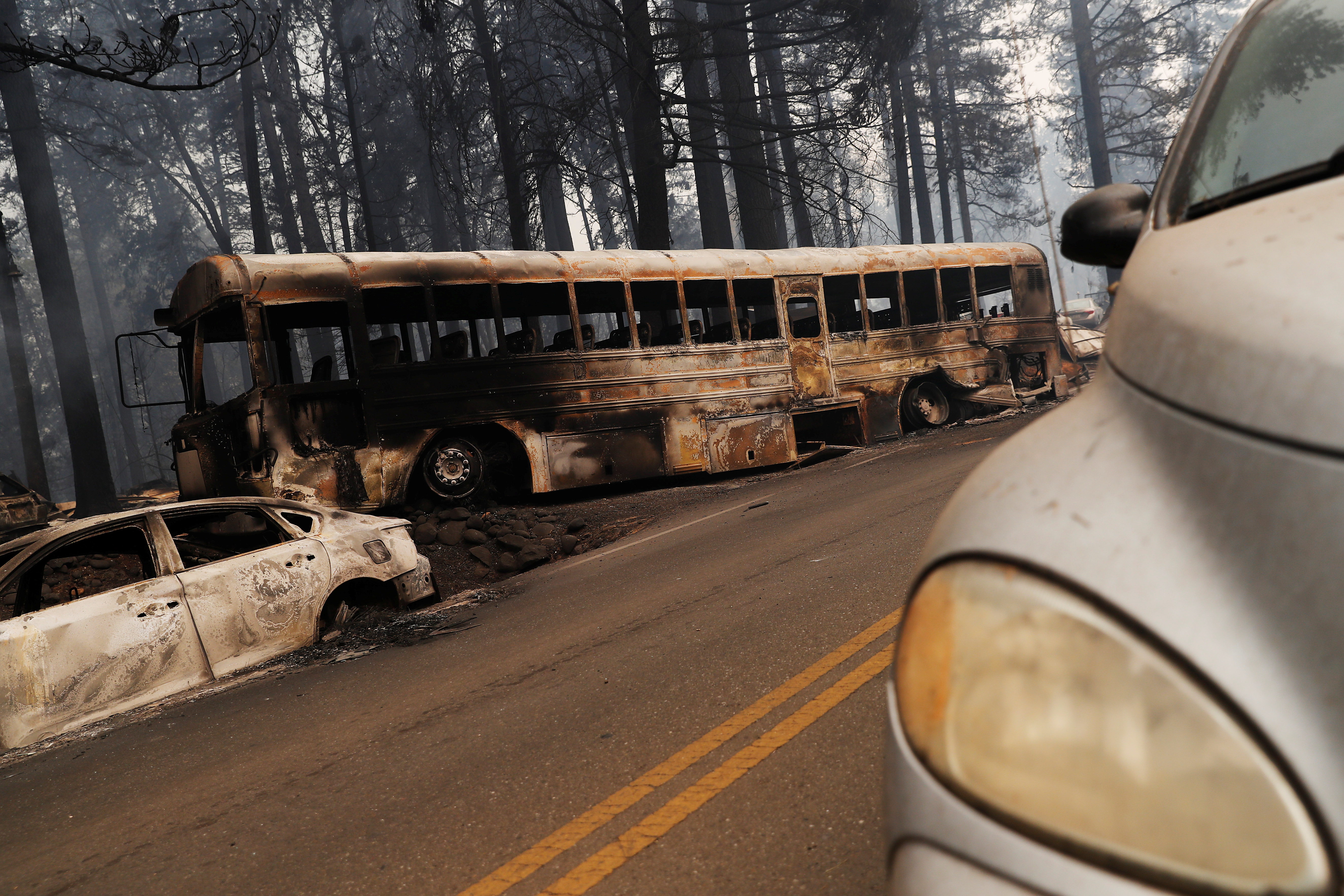 An abandoned and burned school bus is seen on Skyway during the Camp Fire in Paradise