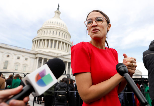 Democratic Representative-elect Ocasio-Cortez talks with reporters as she arrives for class photo for new members of the House on Capitol Hill in Washington