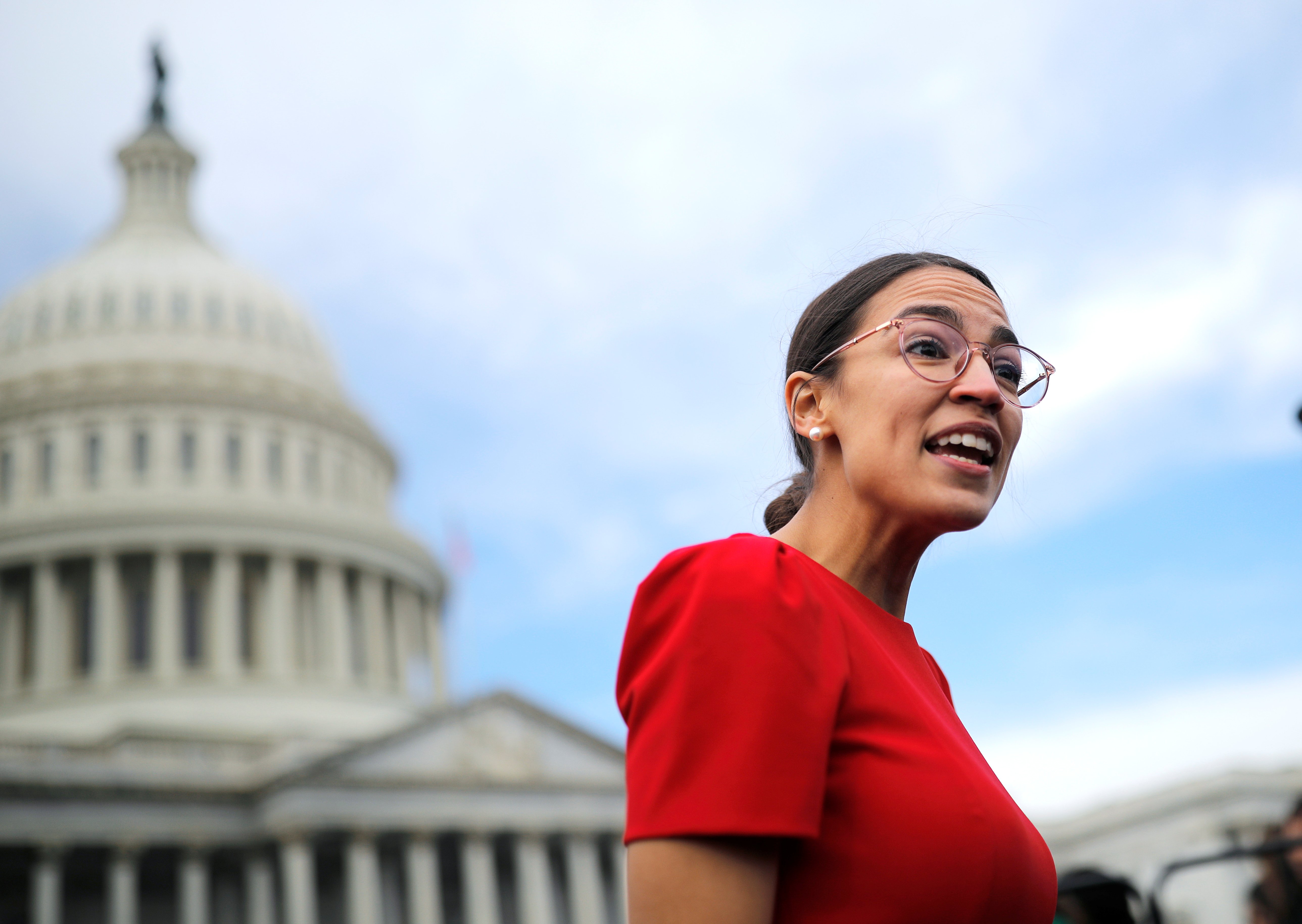 Democratic Representative-elect Ocasio-Cortez talks to reporters as she arrives for class photo for new members of the House on Capitol Hill in Washington