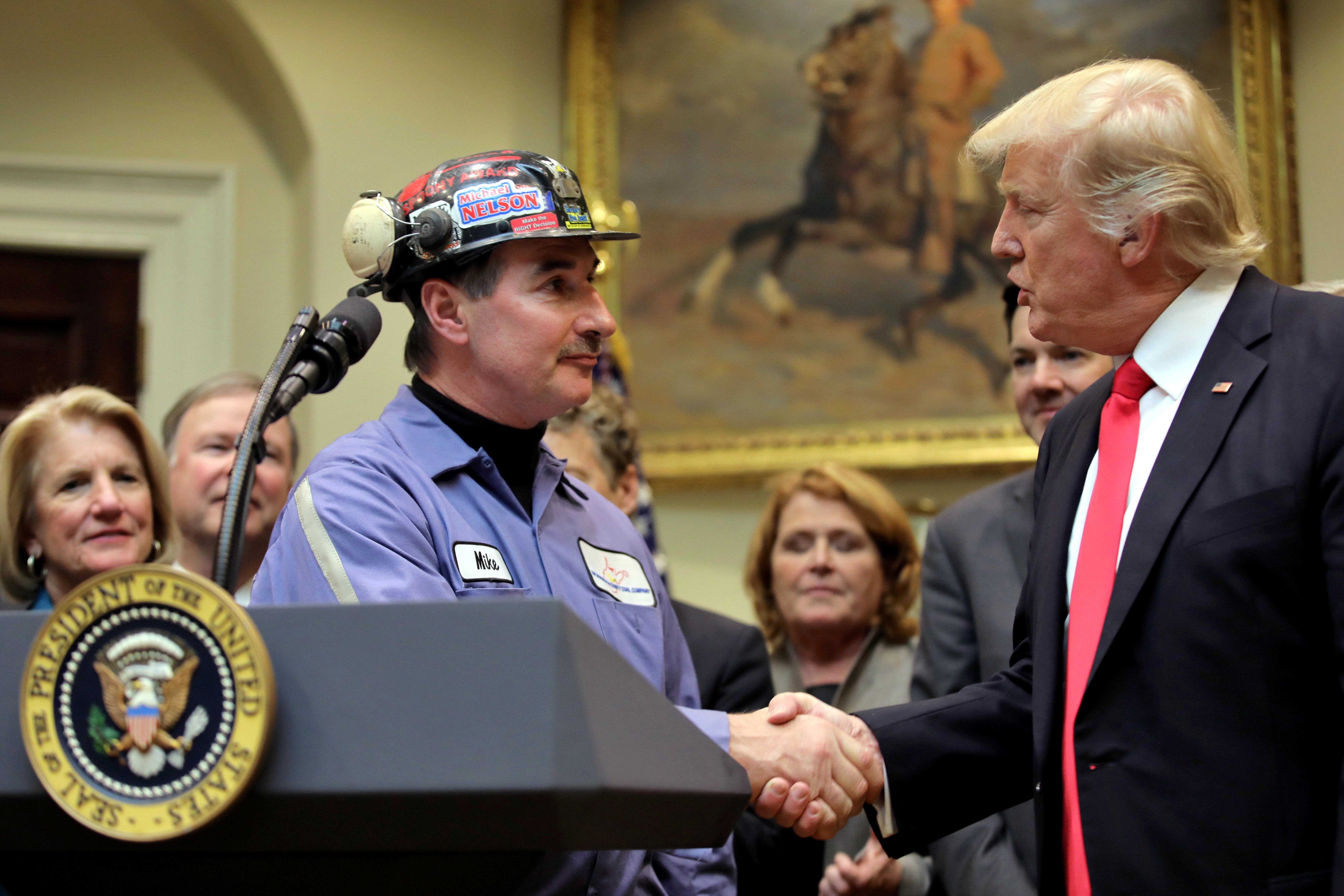 Michael Nelson, a coal miner worker shakes hands with U.S. President Donald Trump as he prepares to sign Resolution 38, at the White House in Washington, U.S.