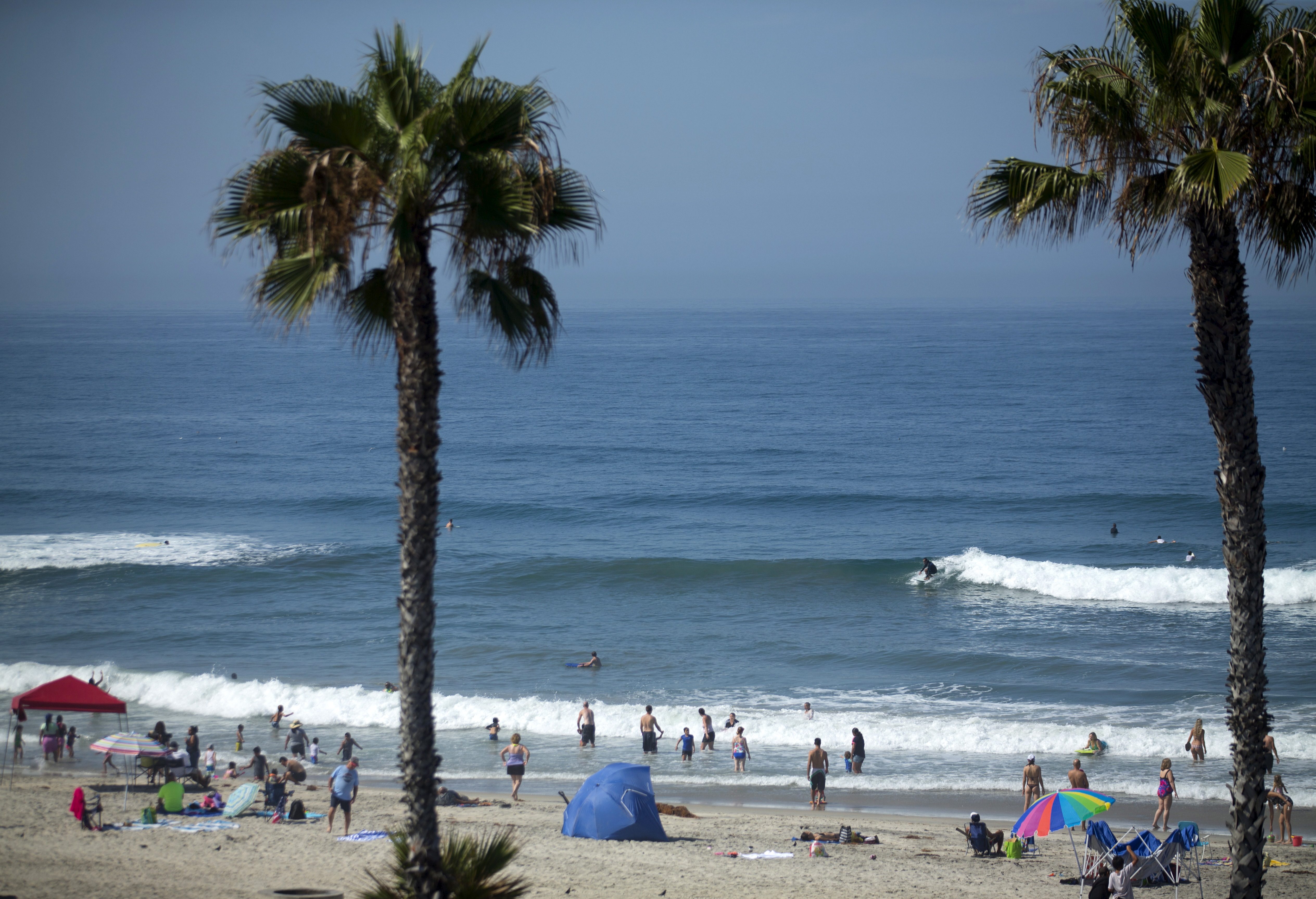 People gather at the beach to cool off as a heat wave brings high temperatures and humidity to Oceanside, California