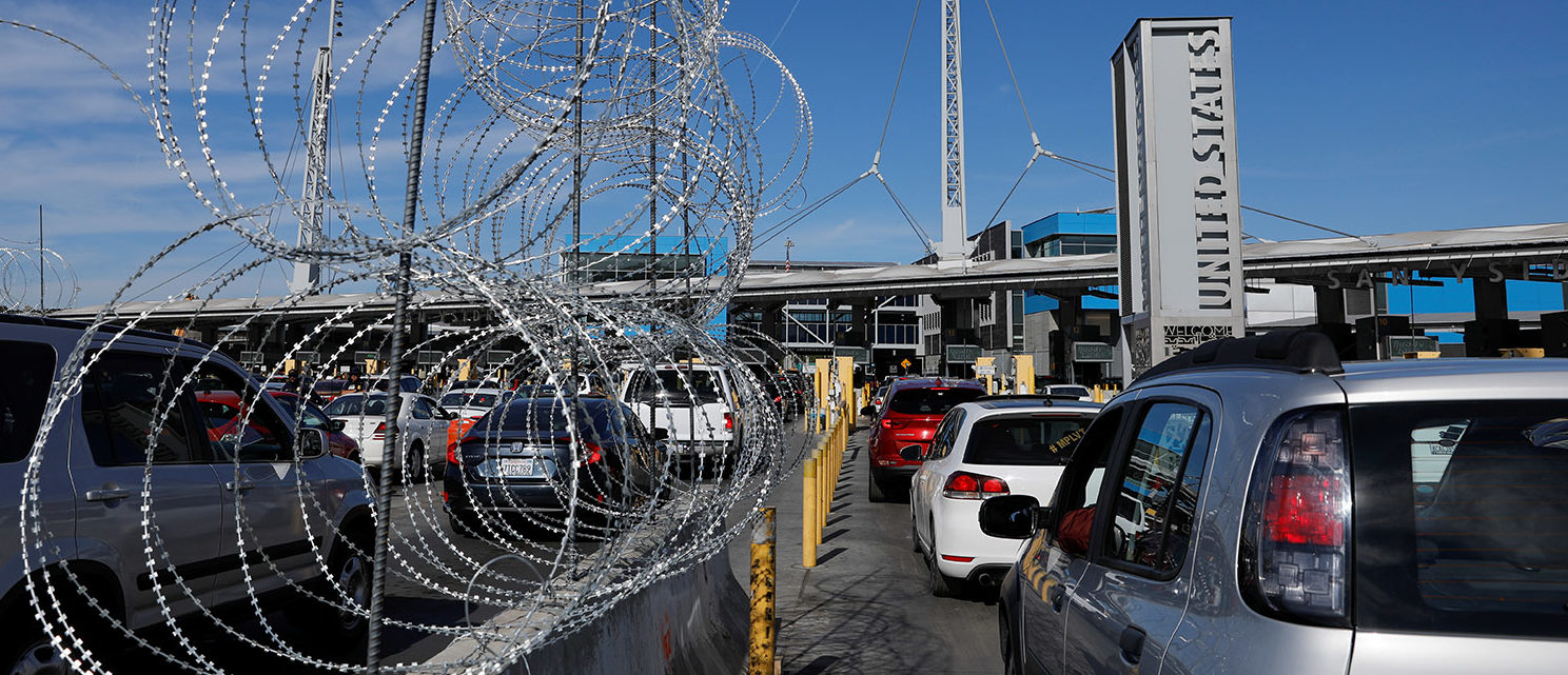 Concertina wire is shown as vehicles enter the United States from Mexico as authorities prepare for the arrival of a caravan of migrants at the San Ysidro border crossing in San Diego, California, U.S. November 15, 2018. REUTERS/Mike Blake