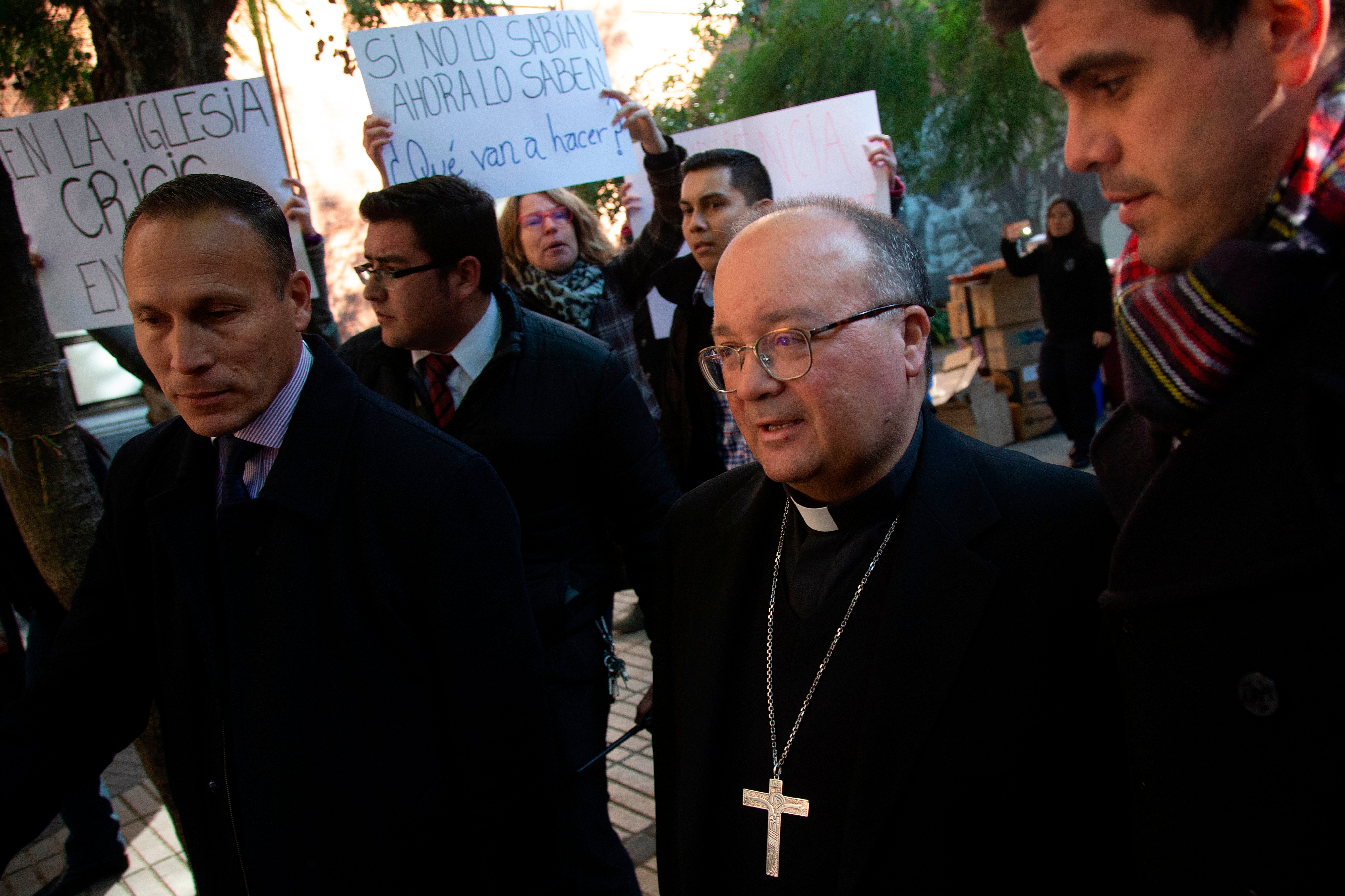 Students demonstrate against the sexual abuse scandal within the Church in Chile as Vatican's top abuse investigator Maltese archbishop Charles Scicluna (R) visits Catholic University in Santiago on June 13, 2018. - Scicluna arrived in Chile on Tuesday, a day after Pope Francis accepted the resignation of three bishops from the scandal-wracked Chilean Church. Maltese archbishop Charles Scicluna and fellow papal envoy Jordi Bertomeu arrived to take witness statements from victims of sexual abuse within the Church and provide instruction to Chilean dioceses to respond adequately to any new complaints. (CLAUDIO REYES/AFP/Getty Images)