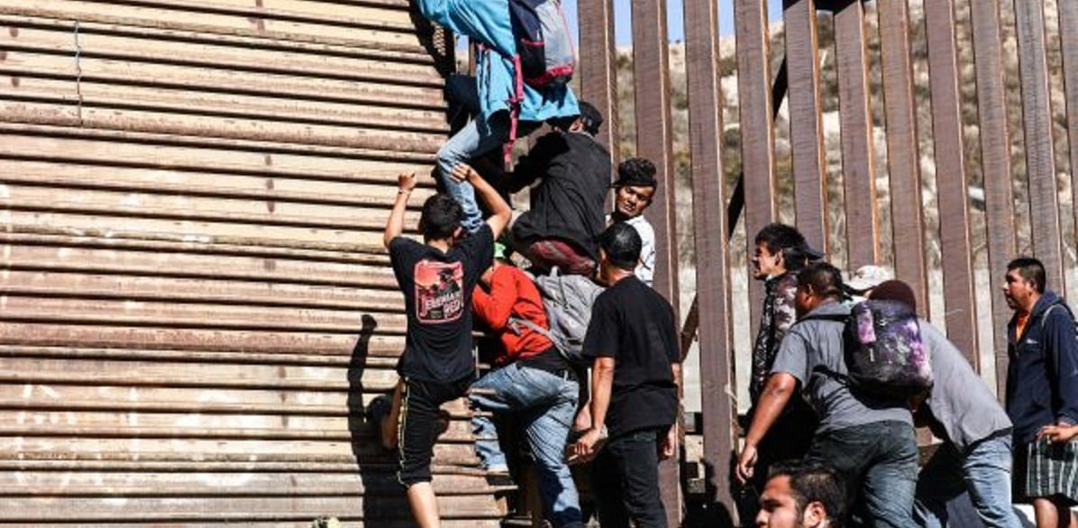 Migrants break through the U.S. border fence just beyond the east pedestrian entrance of the San Ysidro crossing in Tijuana, Mexico, on Nov. 25, 2018. (Charlotte Cuthbertson/The Epoch Times)