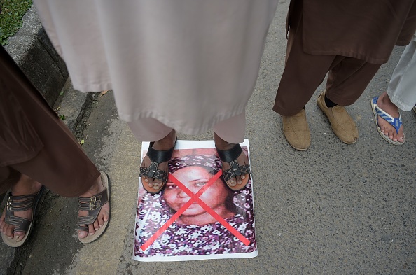 TOPSHOT - A Pakistani supporter of the Ahle Sunnat Wal Jamaat (ASWJ), a hardline religious party, stands over an image of Christian woman Asia Bibi as they march during a protest rally following the Supreme Court's decision to acquit Bibi of blasphemy, in Islamabad on November 2, 2018. (Photo by AAMIR QURESHI / AFP)