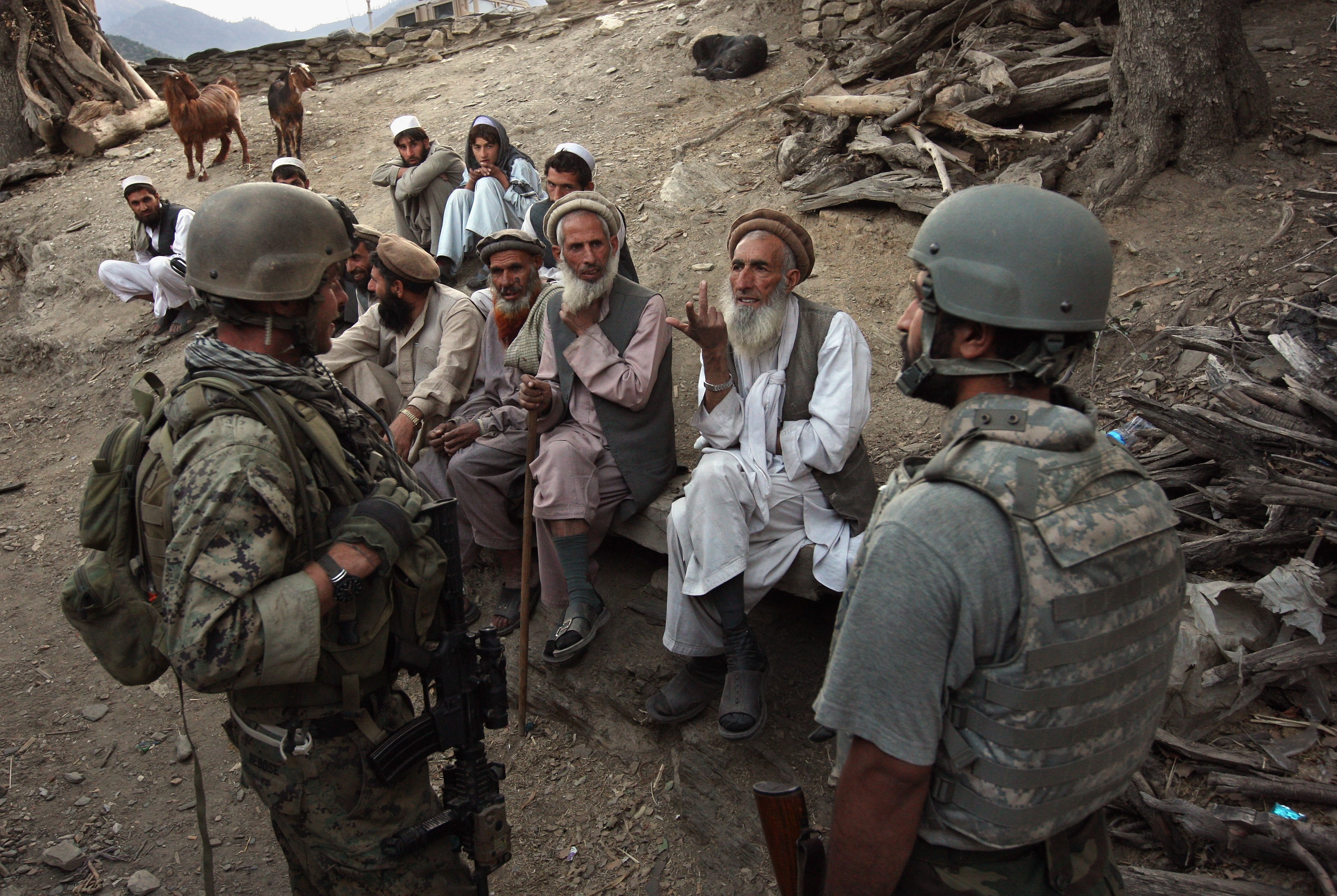 KORENGAL VALLEY, AFGHANISTAN - OCTOBER 25: Village elders speak with a U.S. Marine (L), through an interpreter as American and Afghan forces search for weapons October 25, 2008 in the Korengal Valley of Kunar Province in eastern Afghanistan. (Photo by John Moore/Getty Images)