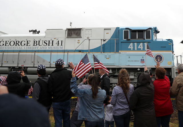 People wave at the train carrying the casket of former U.S. President George H.W. Bush to the George H.W. Bush Presidential Library at Texas A&M University on December 6, 2018 in Navasota, Texas. President Bush will be buried at his final resting place at the George H.W. Bush Presidential Library at Texas A&M University in College Station, Texas. A WWII combat veteran, Bush served as a member of Congress from Texas, ambassador to the United Nations, director of the CIA, vice president and 41st president of the United States. (Photo by Justin Sullivan/Getty Images)