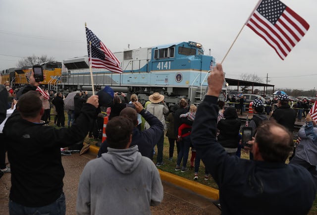 People wave at the train carrying the casket of former U.S. President George H.W. Bush to the George H.W. Bush Presidential Library at Texas A&M University on December 6, 2018 in Navasota, Texas. President Bush will be buried at his final resting place at the George H.W. Bush Presidential Library at Texas A&M University in College Station, Texas. A WWII combat veteran, Bush served as a member of Congress from Texas, ambassador to the United Nations, director of the CIA, vice president and 41st president of the United States. (Photo by Justin Sullivan/Getty Images)