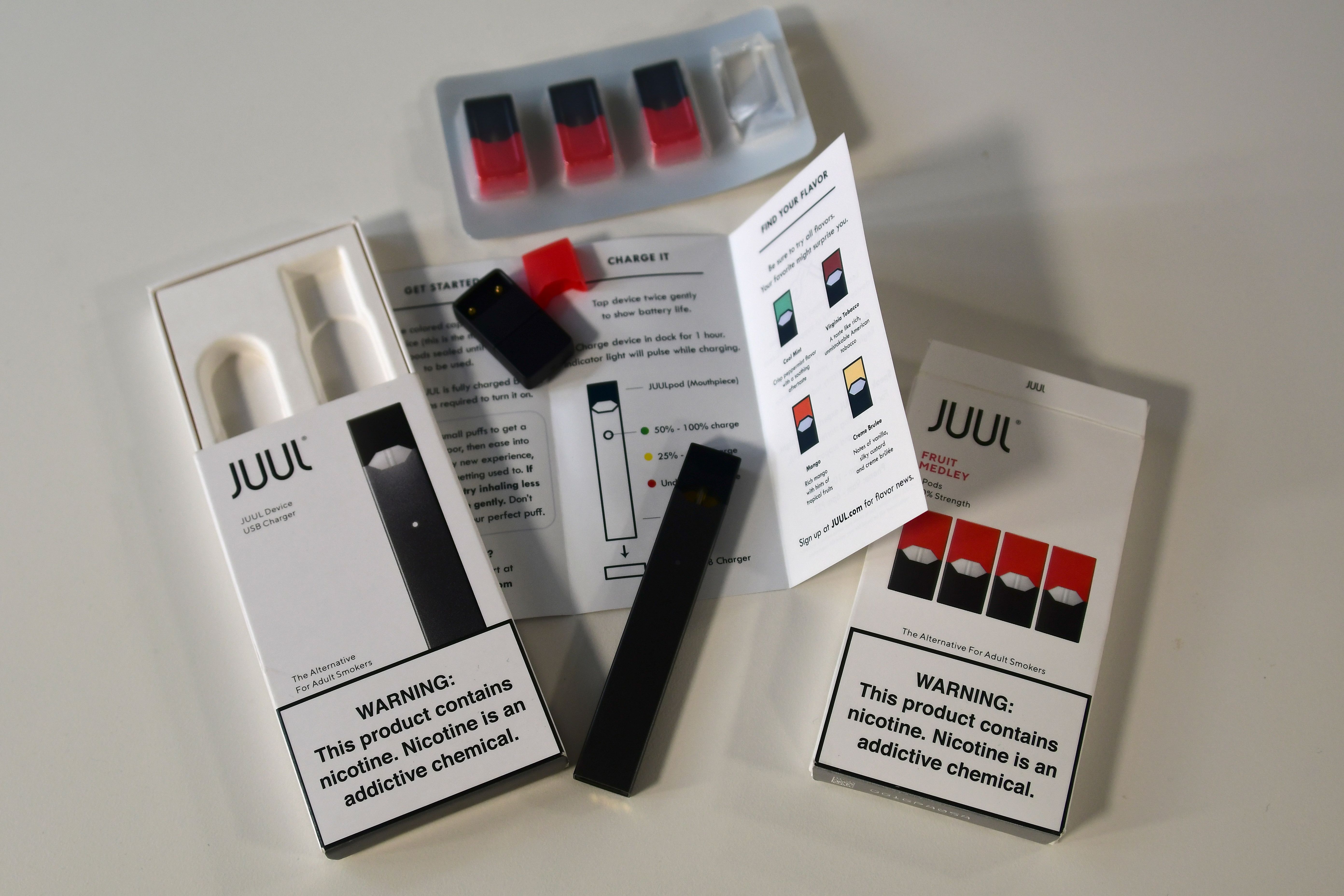 An illustration shows the contents of an electronic Juul cigarette box in Washington, DC October 2, 2018. - In just three years, the electronic cigarette manufacturer Juul has swallowed the American market with its vaporettes in the shape of a USB key. Its success represents a public health dilemma for health authorities in the United States and elsewhere. (Photo by EVA HAMBACH / AFP) 