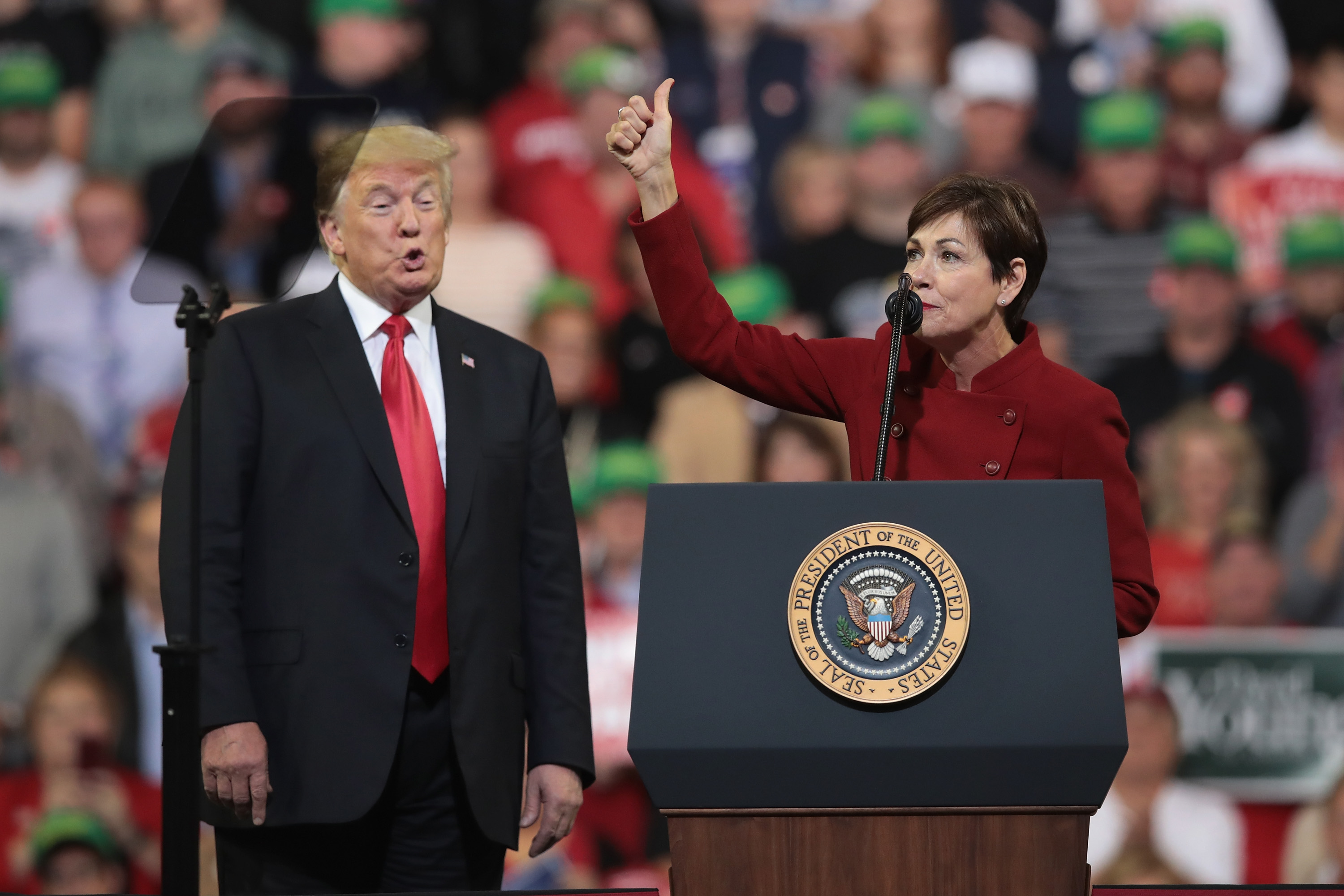 U.S. President Donald Trump listens as Iowa Gov. Kim Reynolds speaks during a campaign rally at the Mid-America Center on October 9, 2018 in Council Bluffs. (Photo by Scott Olson/Getty Images)
