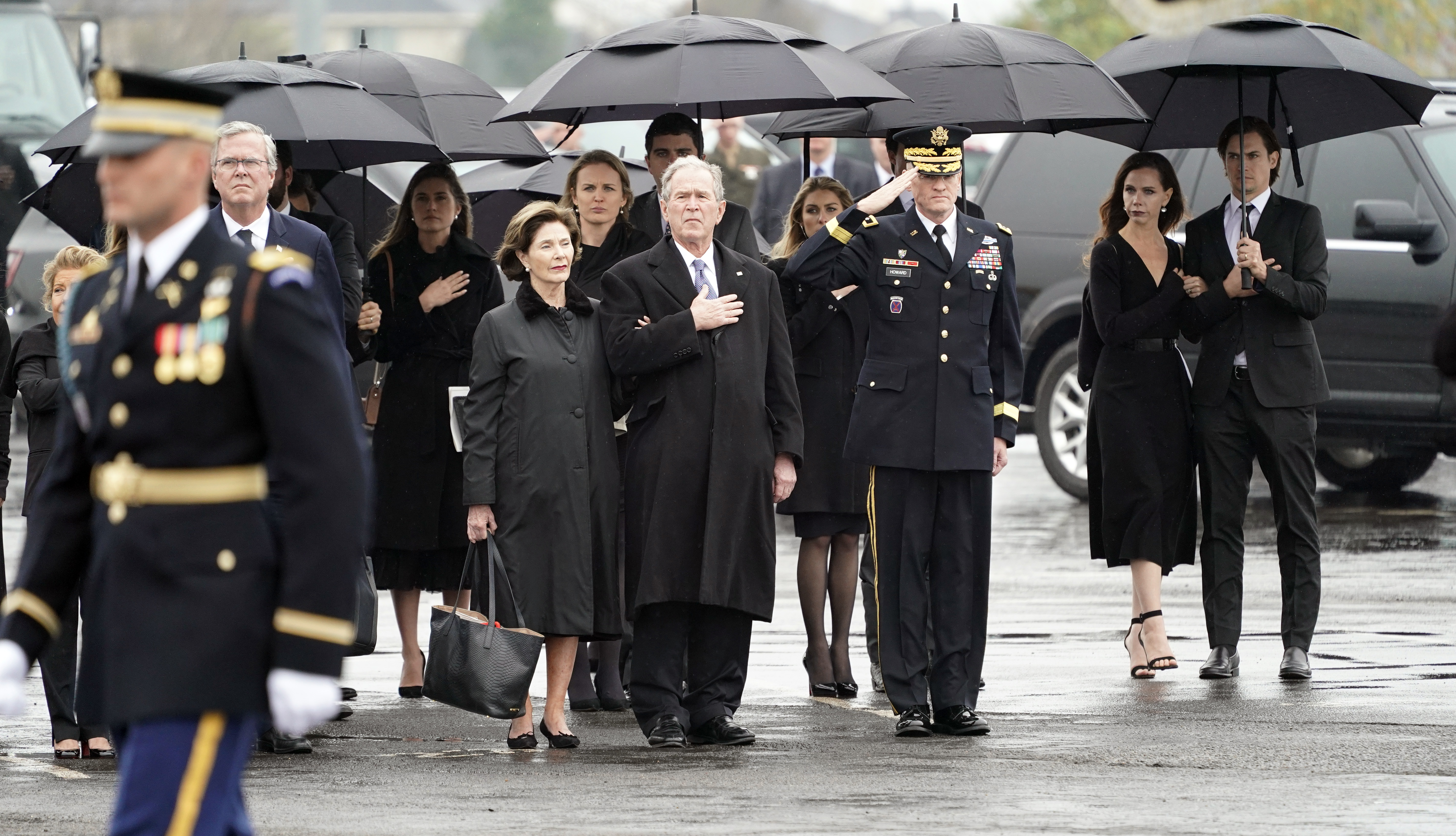 Former President George W. Bush, Laura Bush and other family members watch as the flag-draped casket of former President George H.W. Bush is carried by a joint services military honor guard on December 6, 2018 in Houston, Texas. (Photo by David J. Phillip-Pool/Getty Images)