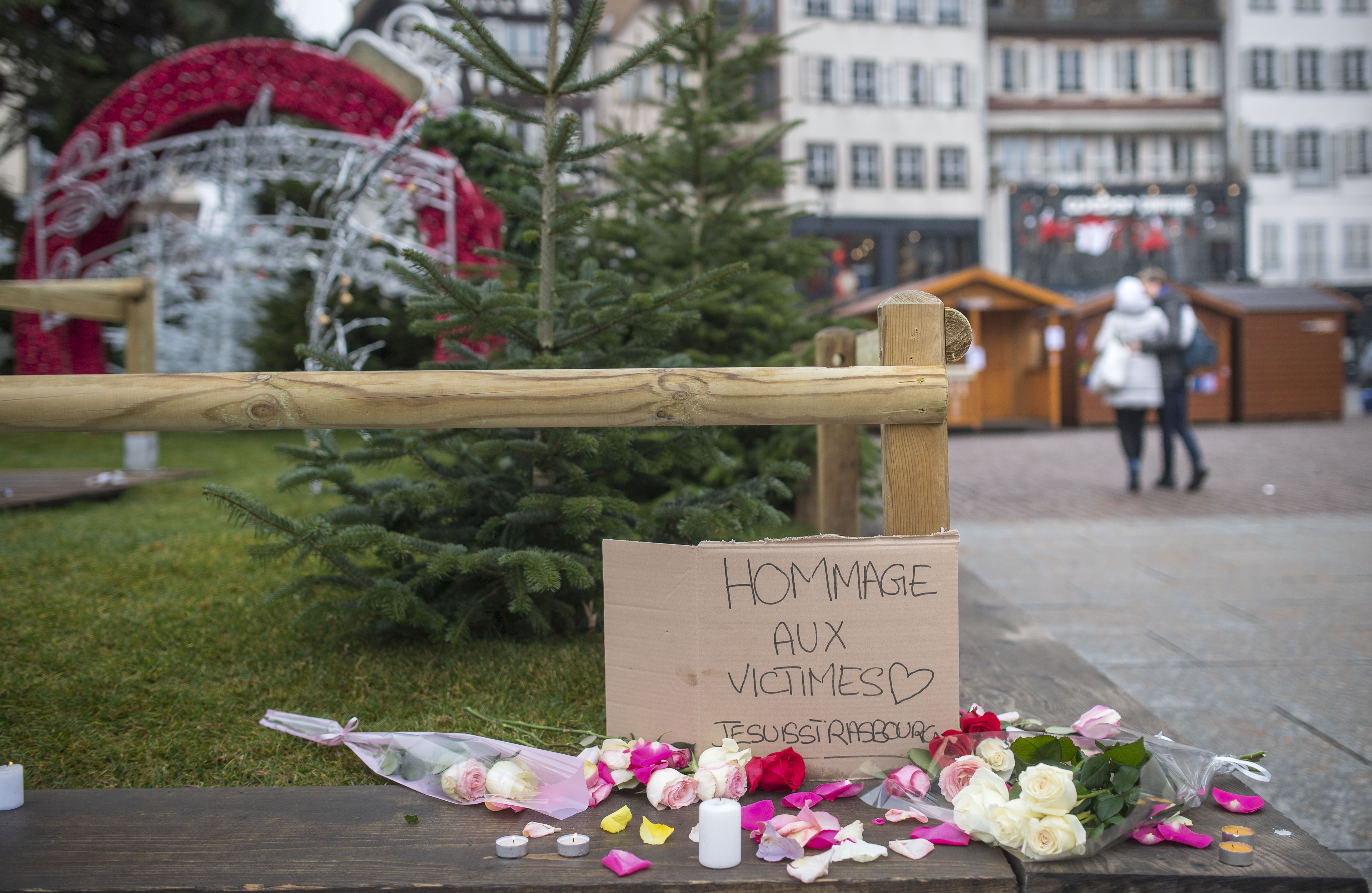 STRASBOURG, FRANCE - DECEMBER 12: Flowers, candles and a sign 'Hommage aux Victimes' pictured at the Christmas market where the day before a man shot 14 people, killing at least three, on December 12, 2018 in Strasbourg, France. Police have identified the man as Cherif Chekatt, a French citizen on a police terror watch-list. Chekatt exchanged gunfire with soldiers after the attack, is reportedly injured and is still on the loose. (Photo by Thomas Lohnes/Getty Images)
