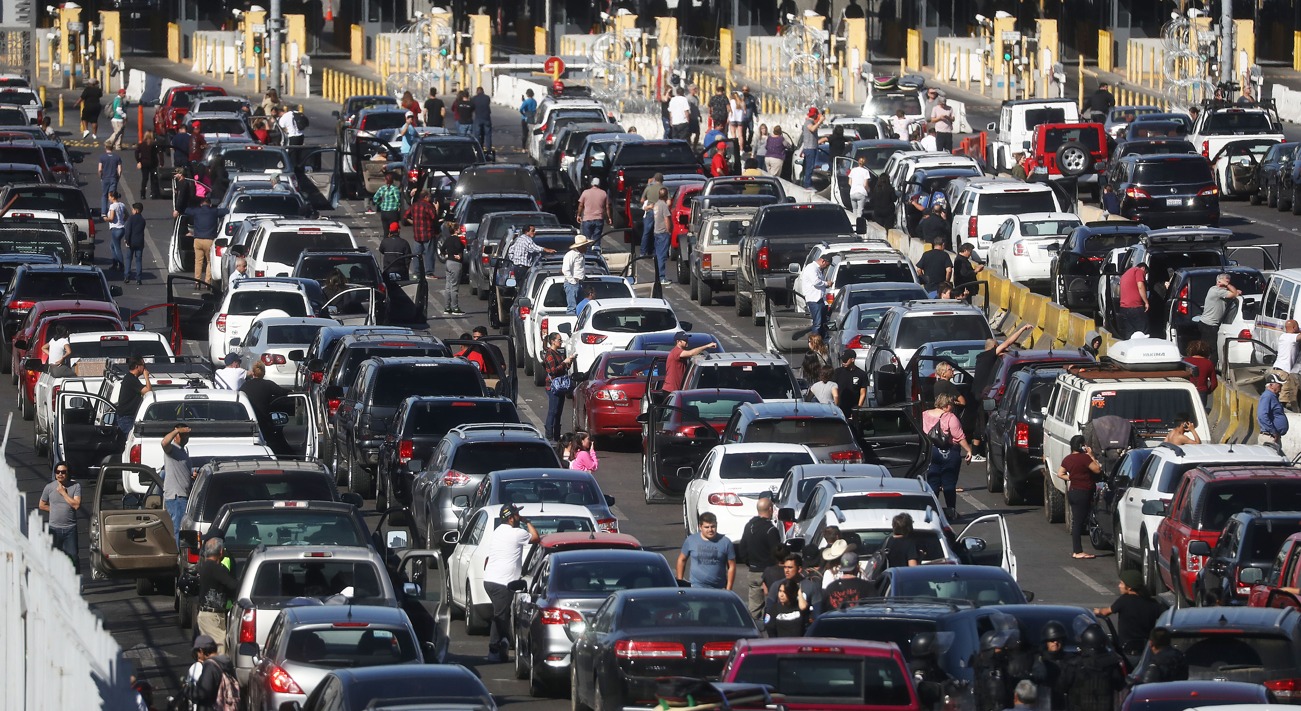TIJUANA, MEXICO - NOVEMBER 25: People attempting to cross into the U.S. look on by their vehicles as the San Ysidro port of entry stands closed at the U.S.-Mexico border on November 25, 2018 in Tijuana, Mexico. Migrants circumvented a police blockade as they attempted to approach the El Chaparral port of entry and U.S. Customs and Border Protection temporarily closed the two ports of entry on the border with Tijuana in response. Around 6,000 migrants from Central America have arrived in the city with the mayor of Tijuana declaring the situation a 'humanitarian crisis'. (Photo by Mario Tama/Getty Images)