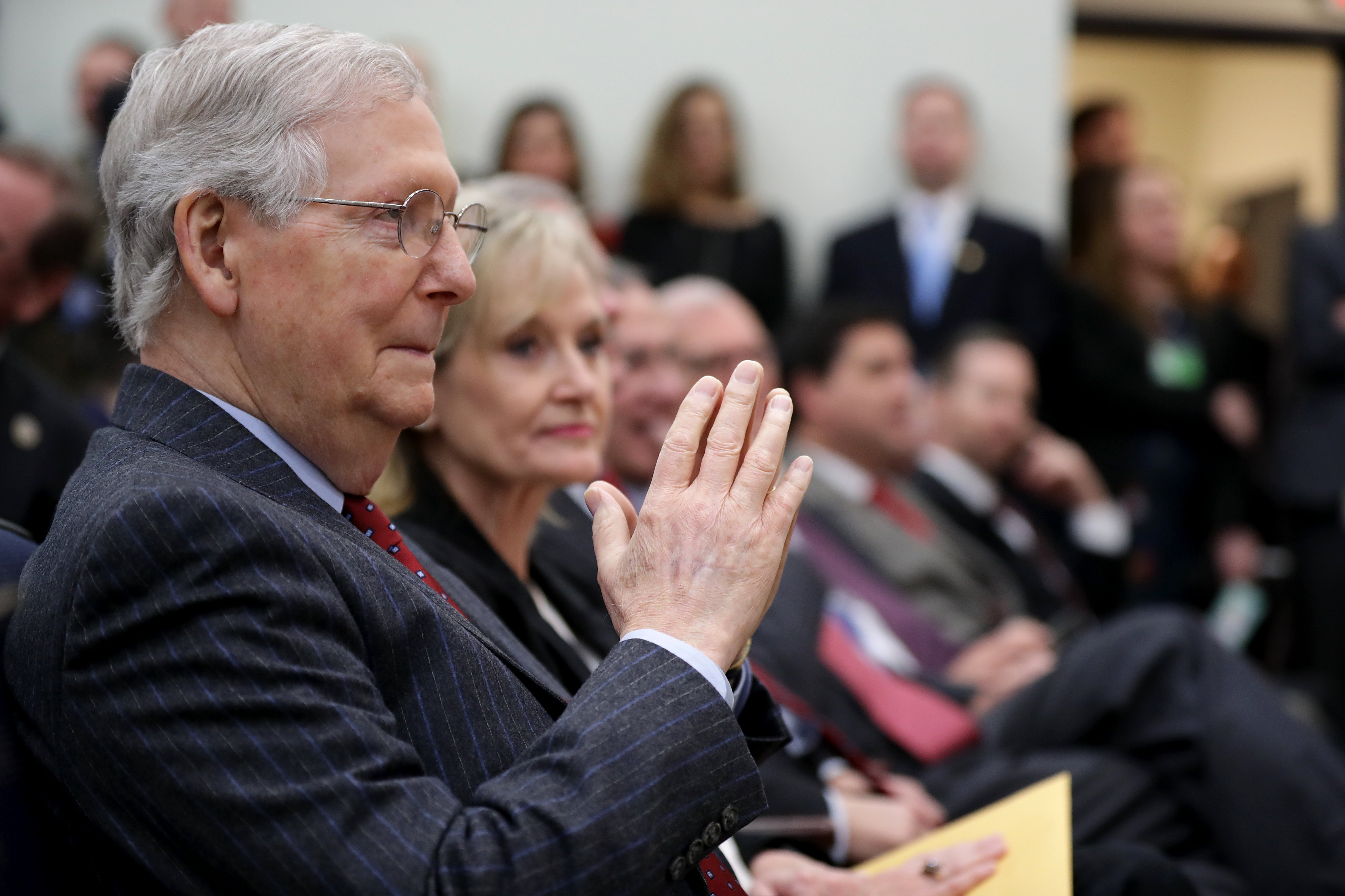 Senate Majority Leader Mitch McConnell (L) joins fellow senators while listening to U.S. President Donald Trump during the signing ceremony for the Agriculture Improvement Act in the South Court Auditorium of the Eisenhower Executive Office Building December 20, 2018 in Washington, DC. (Photo by Chip Somodevilla/Getty Images)