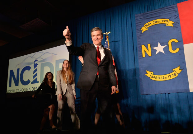 RALEIGH, N.C - NOVEMBER 9: North Carolina Democratic presumptive Governor elect Roy Cooper waves to a crowd at the North Carolina Democratic Watch Party as he walks on stage with his family on November 9, 2016 in Raleigh, North Carolina. North Carolina's gubernatorial race was still too close to call at 1:00 a.m. Cooper stated he felt positive the votes would fall in his favor. (Photo by Sara D. Davis/Getty Images)