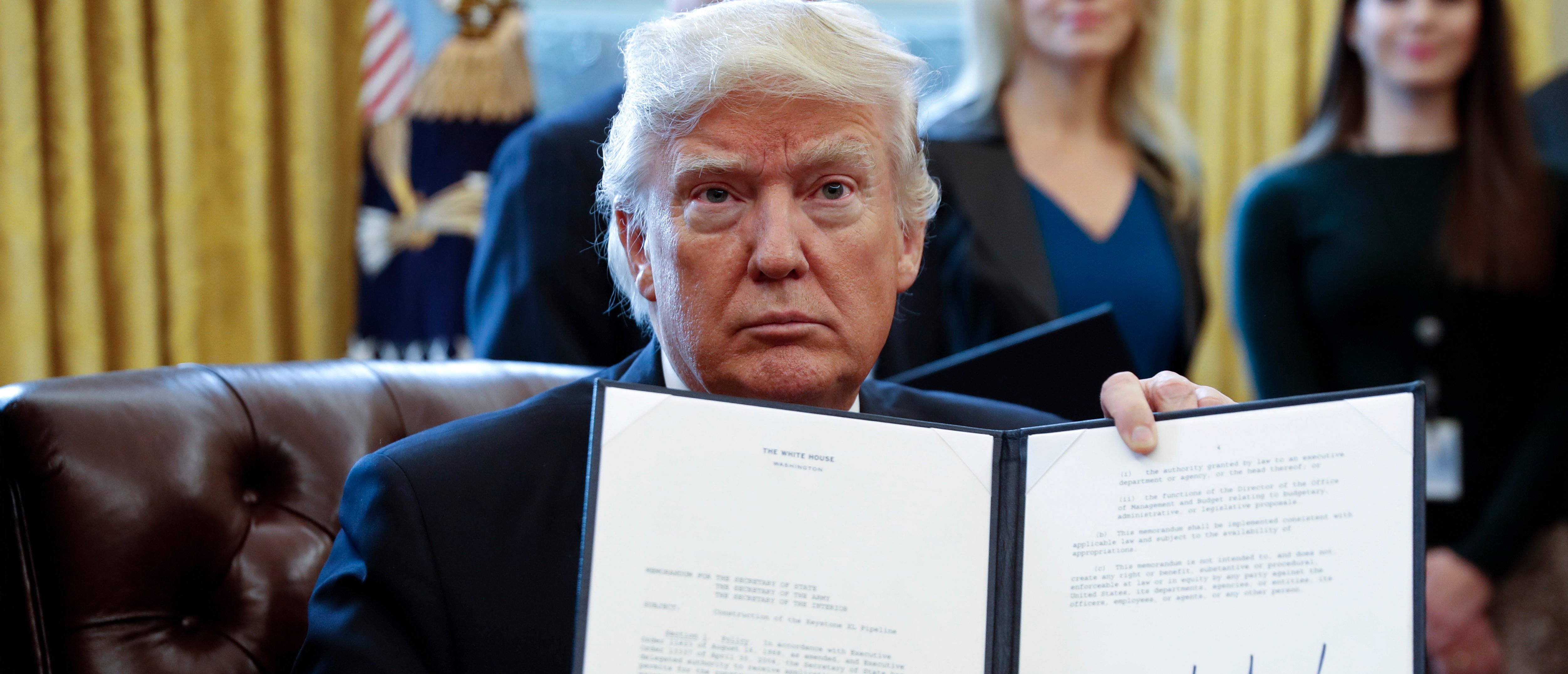 WASHINGTON, DC - JANUARY 24: US President Donald Trump displays one of five executive orders he signed related to the oil pipeline industry in the oval office of the White House January 24, 2017 in Washington, DC. President Trump has a full day of meetings including one with Senate Majority Leader Mitch McConnell and another with the full Senate leadership. (Photo by Shawn Thew-Pool/Getty Images)