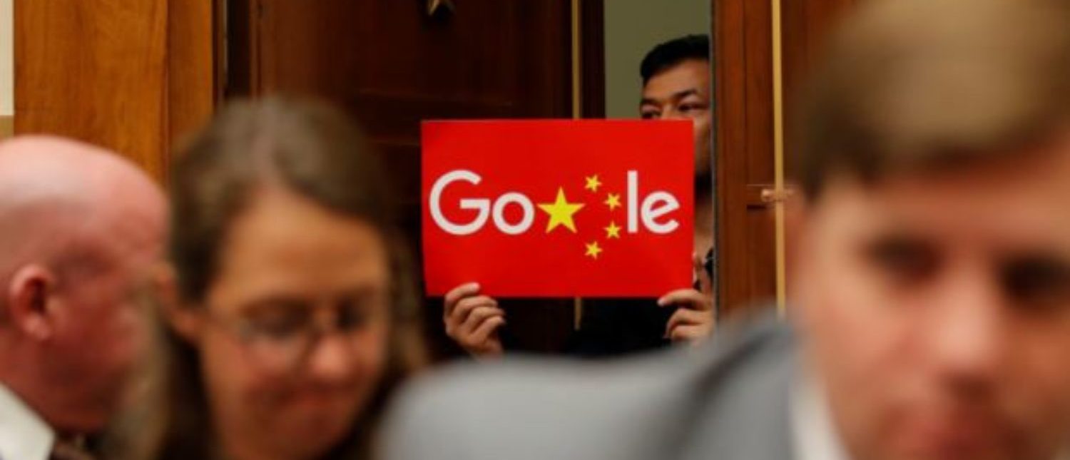 A demonstrator holds up a sign in the doorway as Google CEO Sundar Pichai testifies at a House Judiciary Committee on greater transparency in Washington, U.S., Dec. 11, 2018. REUTERS/Jim Young