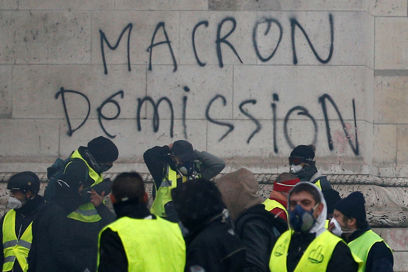 The message "Macron Resign" is seen on the Arc de Triomphe as protesters wearing yellow vests, a symbol of a drivers' protest against higher diesel taxes, demonstrate at the Place de l'Etoile in Paris, France, December 1, 2018. Picture taken Decembert 1, 2018. REUTERS/Stephane Mahe