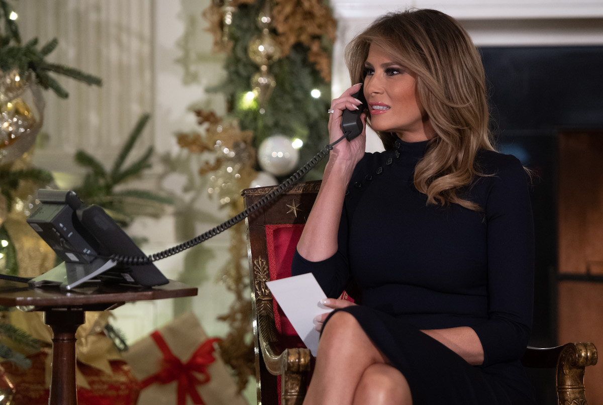 First Lady Melania Trump speaks on the telephone as he answers calls from people calling into the NORAD Santa tracker phone line in the State Dining Room of the White House in Washington, DC, on December 24, 2018. (Photo credit: SAUL LOEB/AFP/Getty Images)
