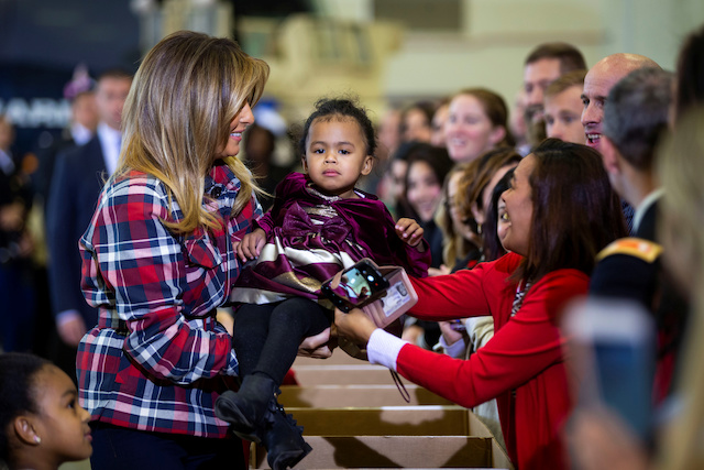 U.S. first lady Melania Trump is handed a young girl during the Marine Corps Reserve Toys for Tots campaign at Joint Base Anacostia-Bolling in Washington, U.S., December 11, 2018. REUTERS/Al Drago 