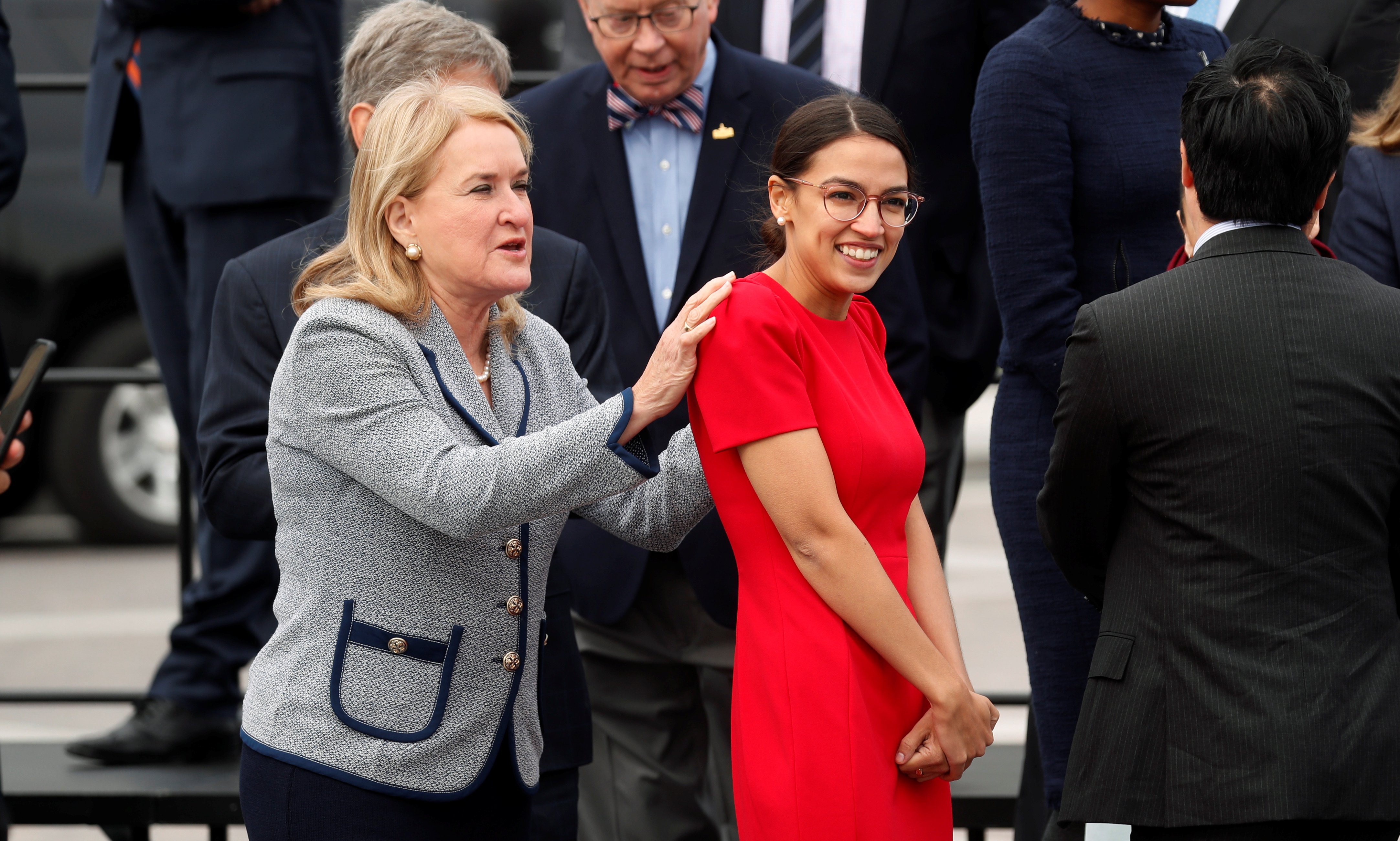 Democratic Representative-elect Wild puts hands on Ocasio-Cortez shoulders as they arrive for class photo for new members of the House on Capitol Hill in Washington