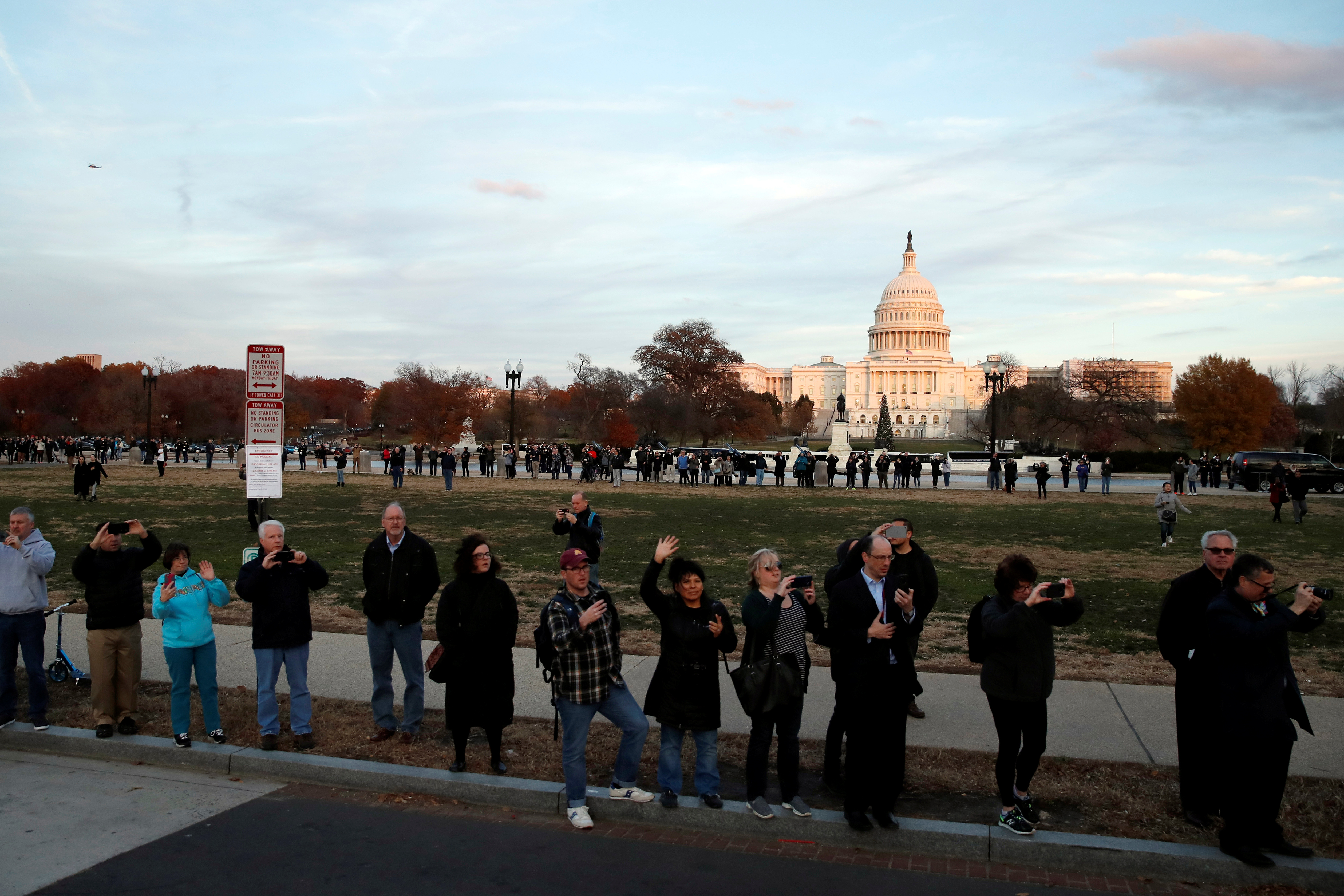 People watch as the hearse carrying the remains of former President George H.W. Bush passes by the West Front of the U.S. Capitol, in Washington, U.S., December 3, 2018. (Alex Brandon/Pool via REUTERS)