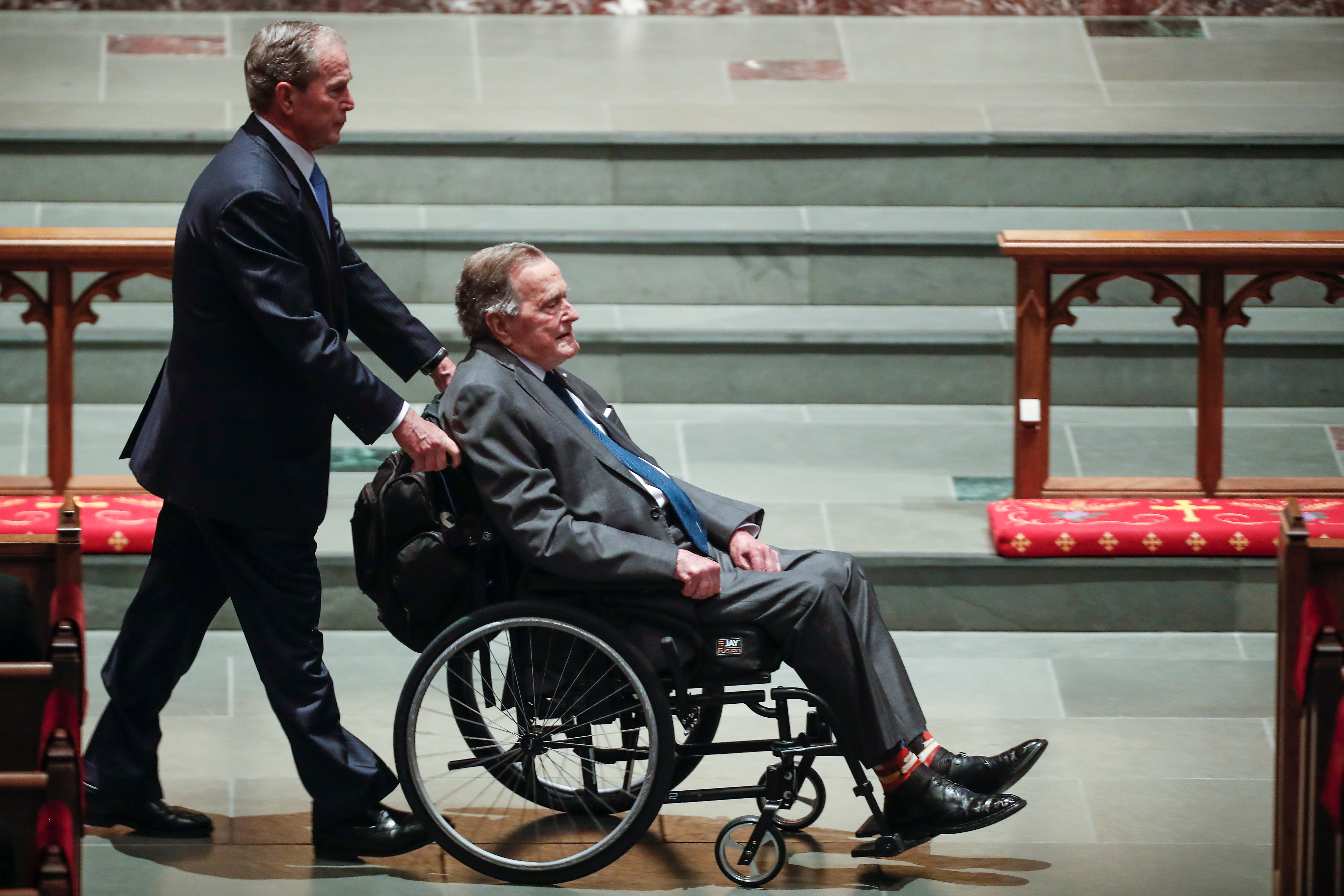 HOUSTON, TX - APRIL 21: Former president George W. Bush, left, wheels his father, former president George H.W. Bush into the church for the funeral for former first lady Barbara Bush at St. Martin's Episcopal Church on April 21, 2018 in Houston, Texas. Bush, wife of former president George H. W. Bush and mother of former president George W. Bush, died at her home in Houston on April 17 at the age of 92. (Photo by Brett Coomer - Pool/Getty Images)