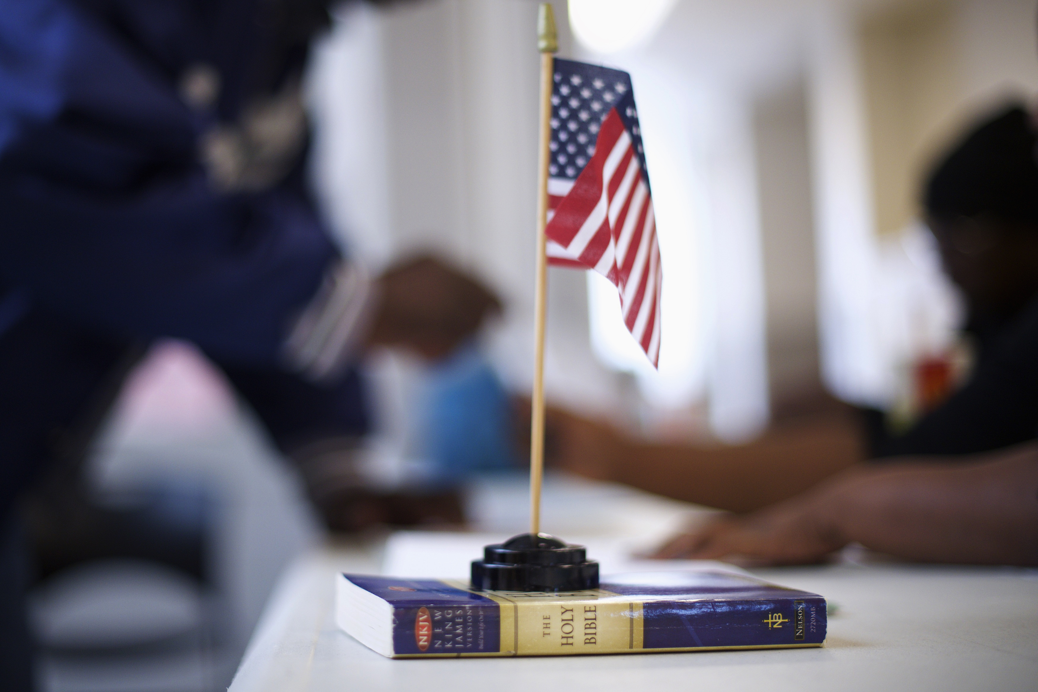 A miniature U.S. flag rests on a copy of the Bible at voter registration at West Philadelphia High School on U.S. midterm election day morning in Philadelphia, Pennsylvania, November 4, 2014. REUTERS/Mark Makela
