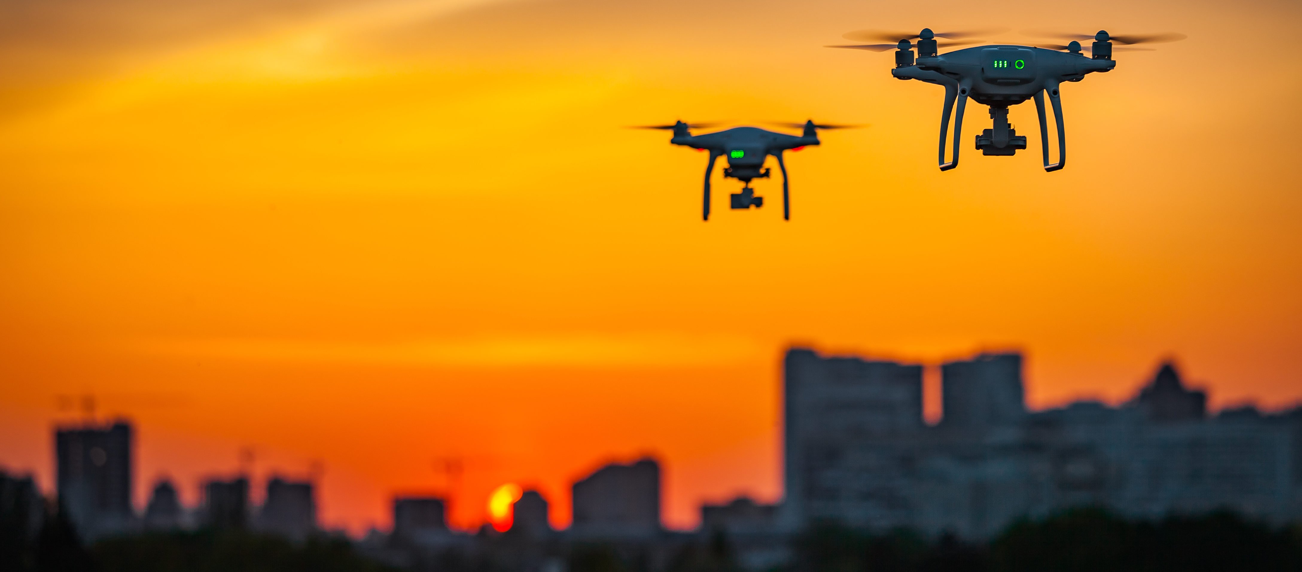 Drones fly above a city at night. (Shutterstock/Volodymyr Goinyk)