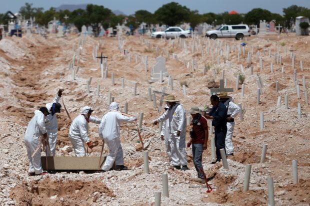 Forensic workers bury one of 40 unidentified bodies at the San Rafael cemetery in Ciudad Juarez, Chihuahua State, Mexico, on July 23, 2018. (Photo by CARLOS SANCHEZ / AFP / Getty Images)